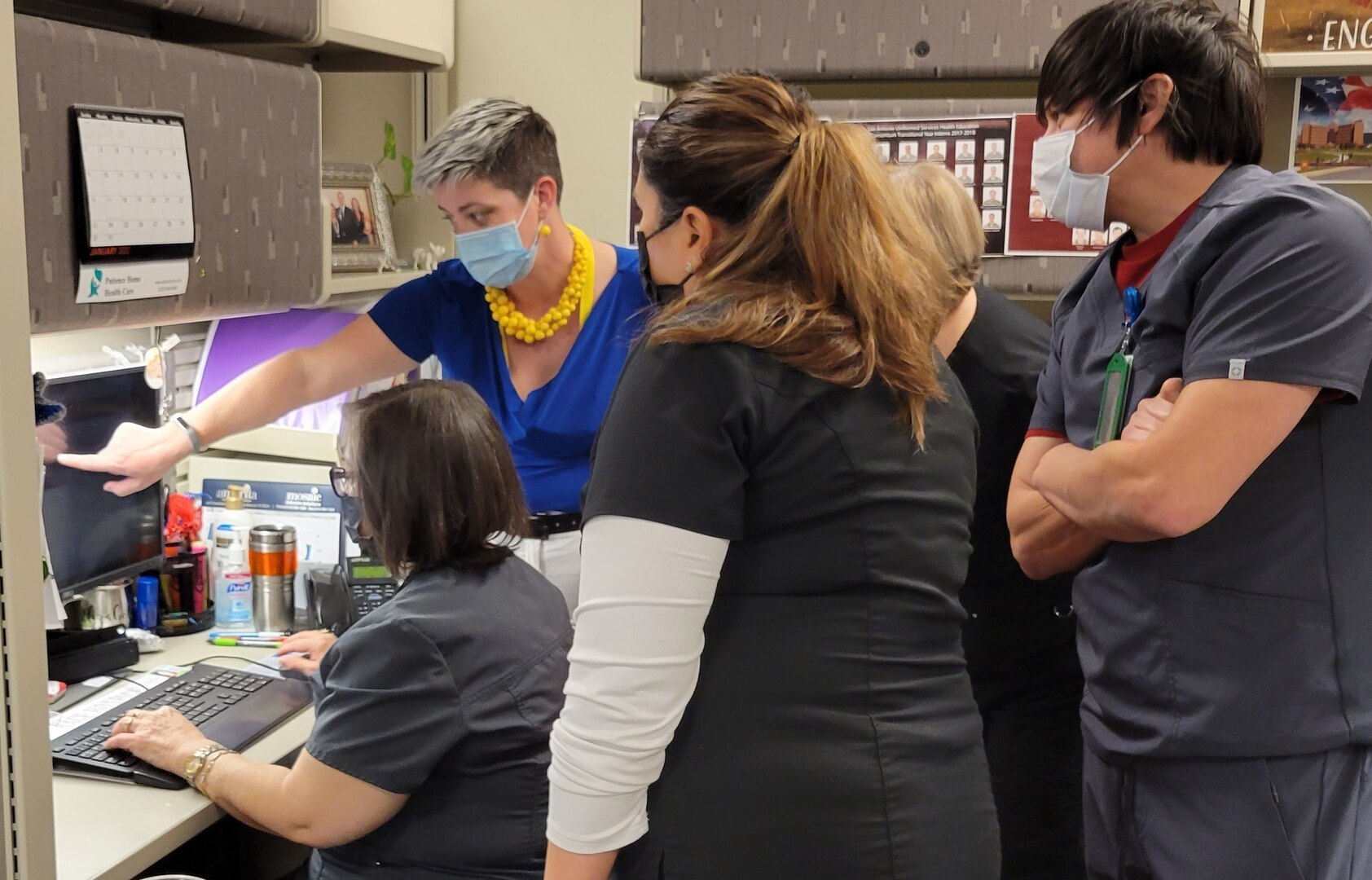 Lisa Clark, a Pay it Forward team member from Naval Hospital Twentynine Palms, shows Brooke Army Medical Center case managers how to input data into the MHS GENESIS system at BAMC, Joint Base San Antonio-Fort Sam Houston, Texas, Jan. 22, 2022. Pay it Forward team members come from sites that have implemented MHS GENESIS to help with the transition to the new system.