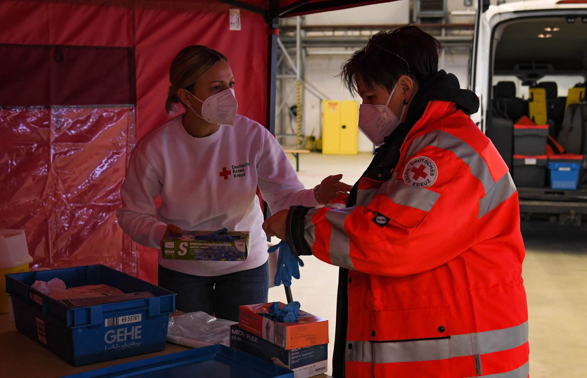 Sabrina Johns (left) and Christiane Malburg (right), German Red Cross immunizers, prepare to administer COVID-19 vaccines and booster shots at Ramstein Air Base, Germany, Jan. 25, 2022. German Red Cross medics administered approximately 500 vaccinations to base personnel and family members. (U.S. Air Force photo by Airman 1st Class Jared Lovett)