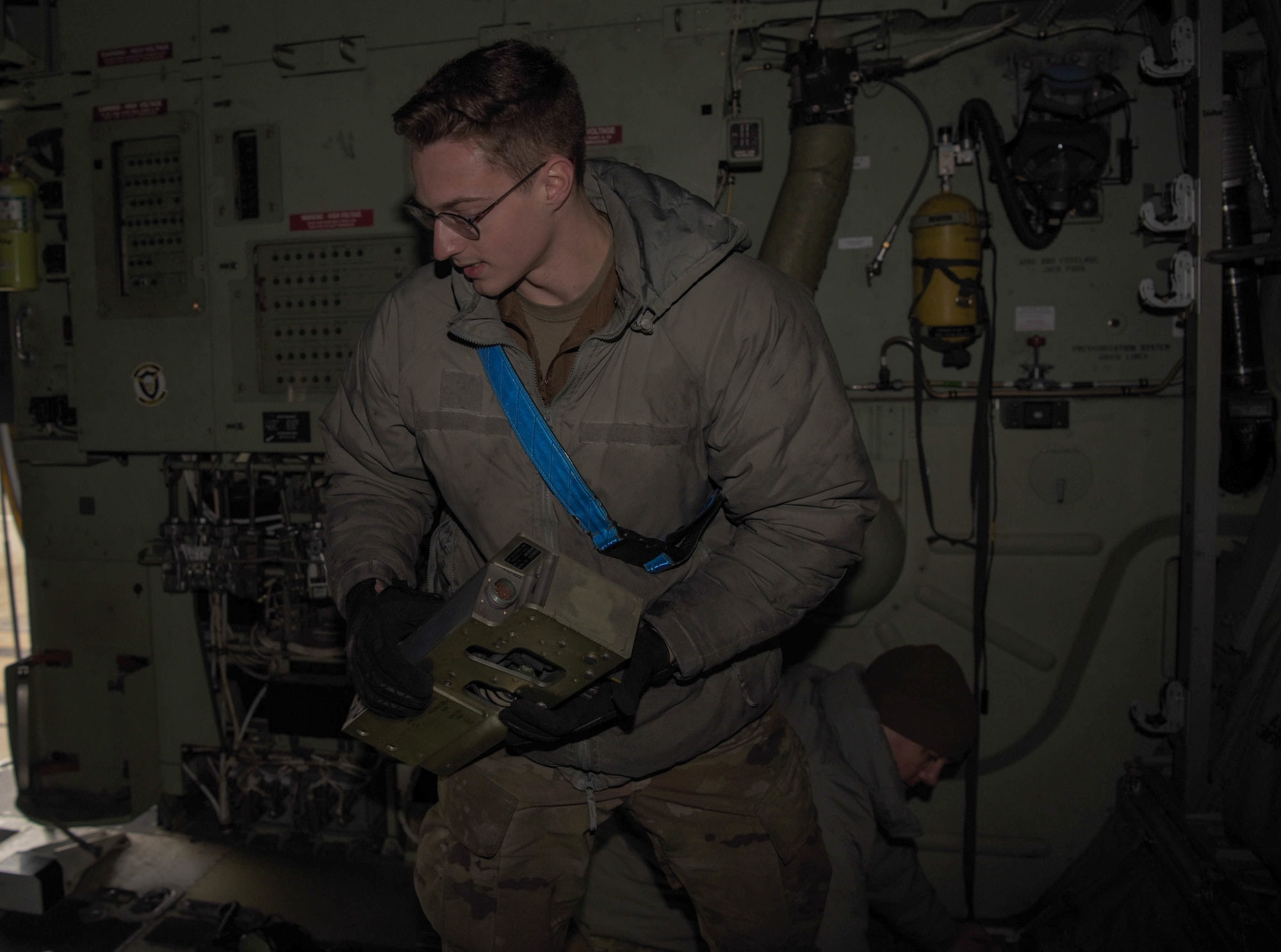 Airman moves equipment on aircraft.