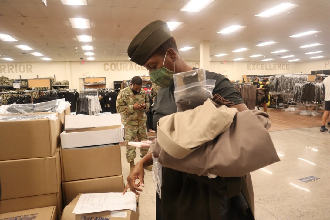 a soldier tries on a dress uniform cap