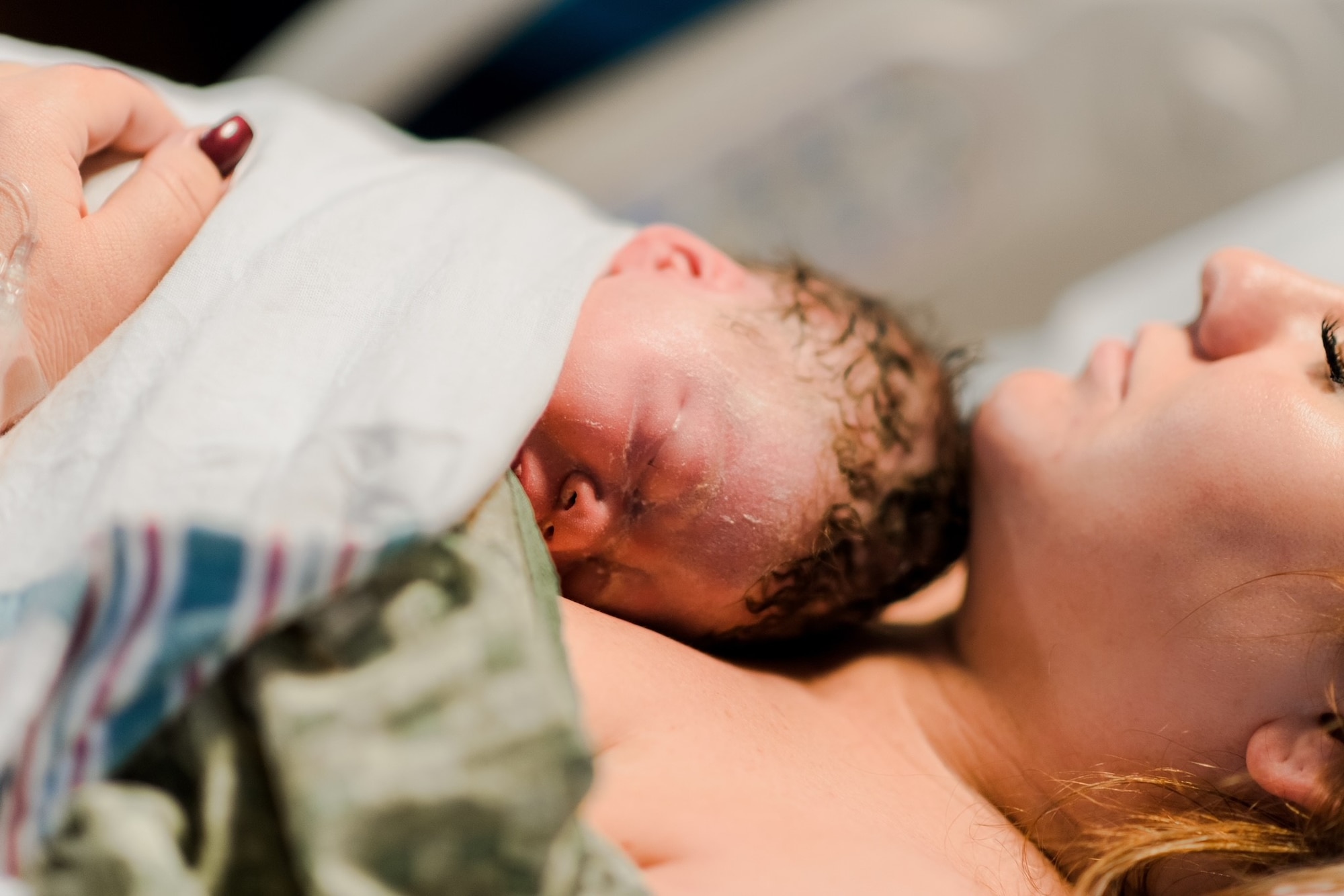 U.S. Air Force Senior Airman Cheyenne Lewis, 325th Fighter Wing public affairs journeyman, embraces her newborn child.