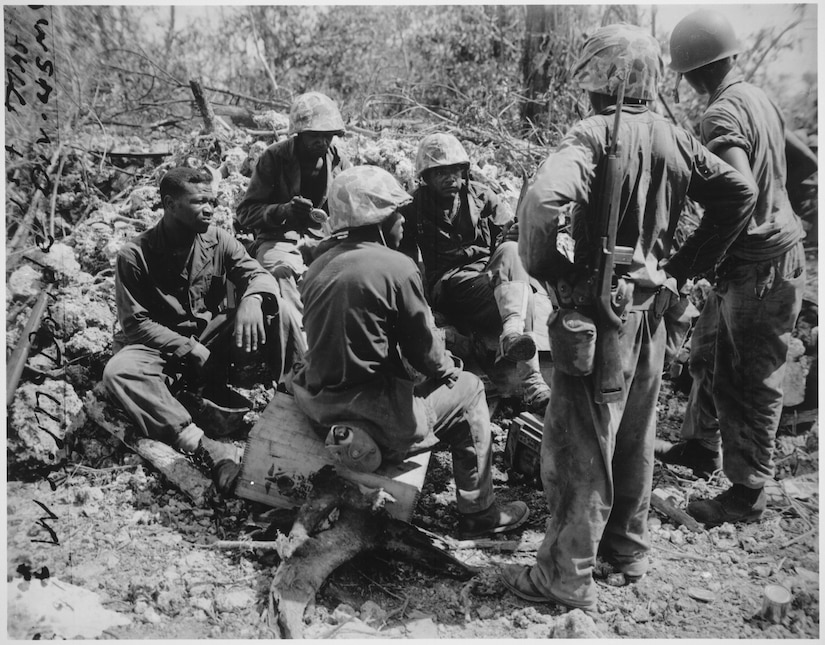 Troops rest amid rubble.