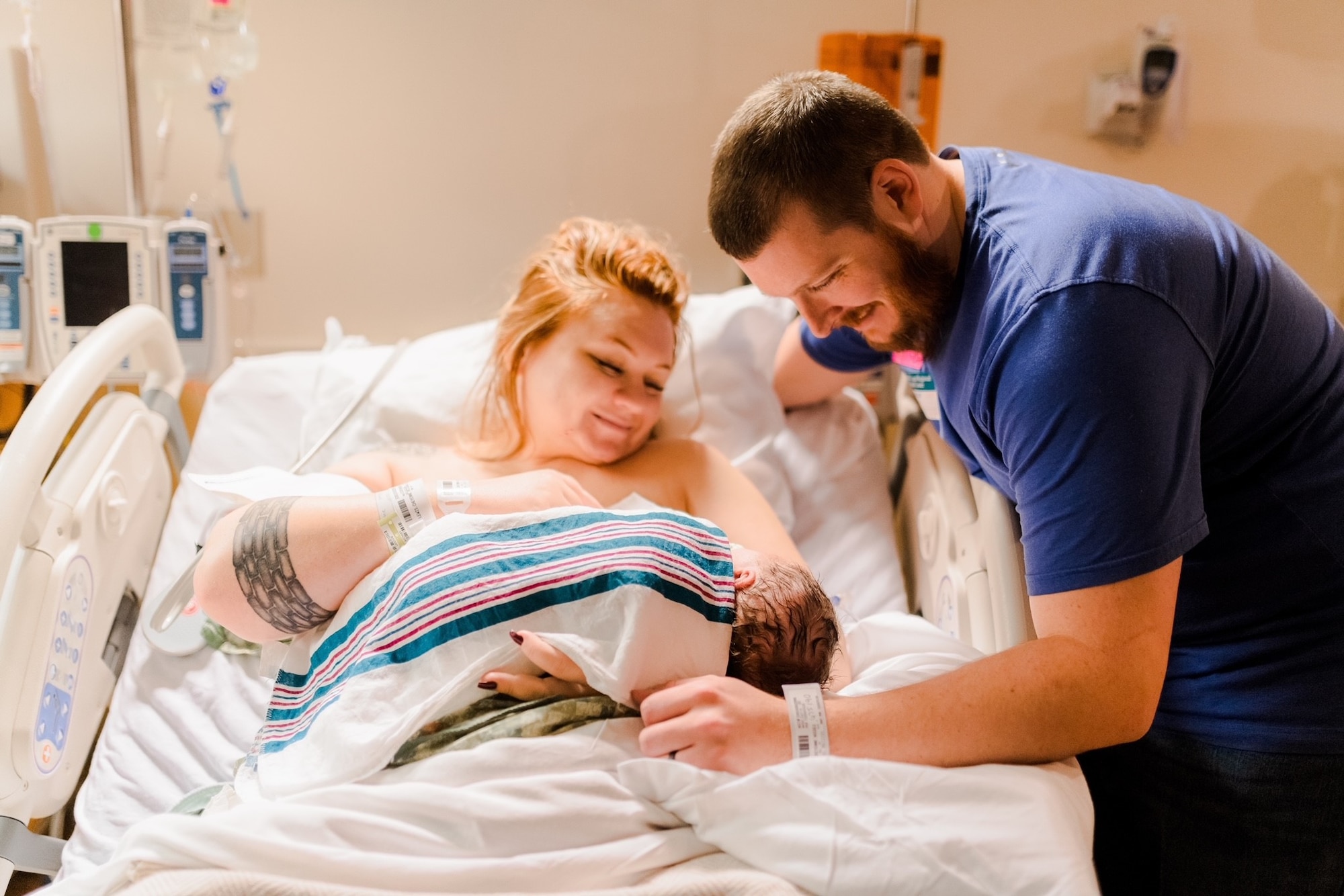 U.S. Air Force Senior Airman Cheyenne Lewis. 325th Fighter Wing public affairs journeyman, and her spouse look upon their newborn son.