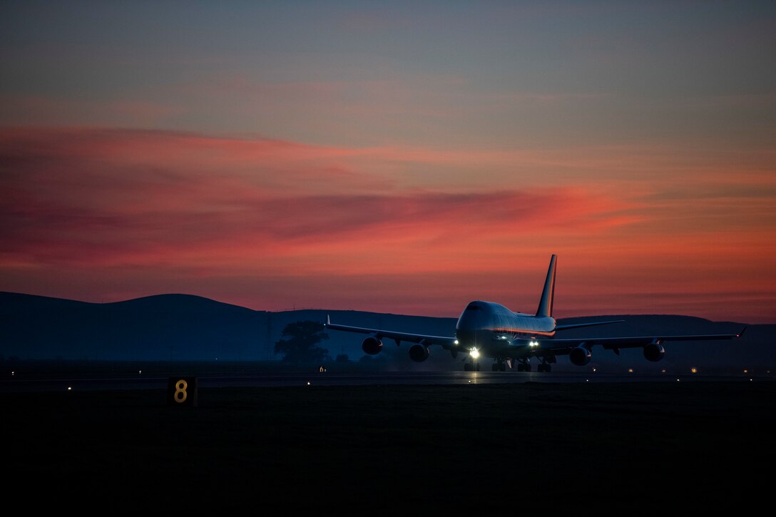 A large plane takes off at twilight.