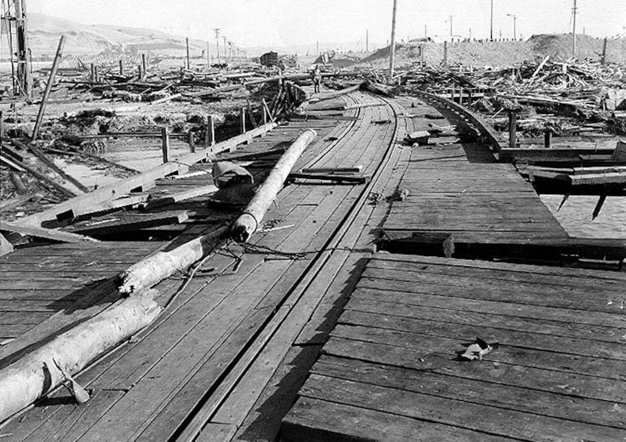 Broken poles and debris litter an outdoor area.