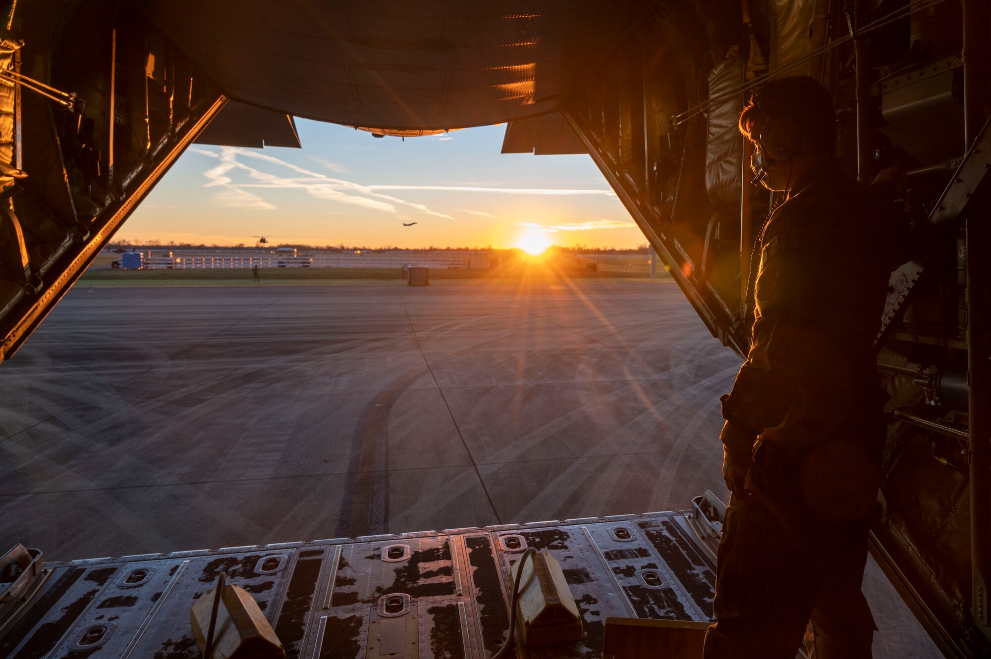 A loadmaster from the 317th Airlift Wing at Dyess Air Force Base, Texas, looks out the back of a C-130J Super Hercules