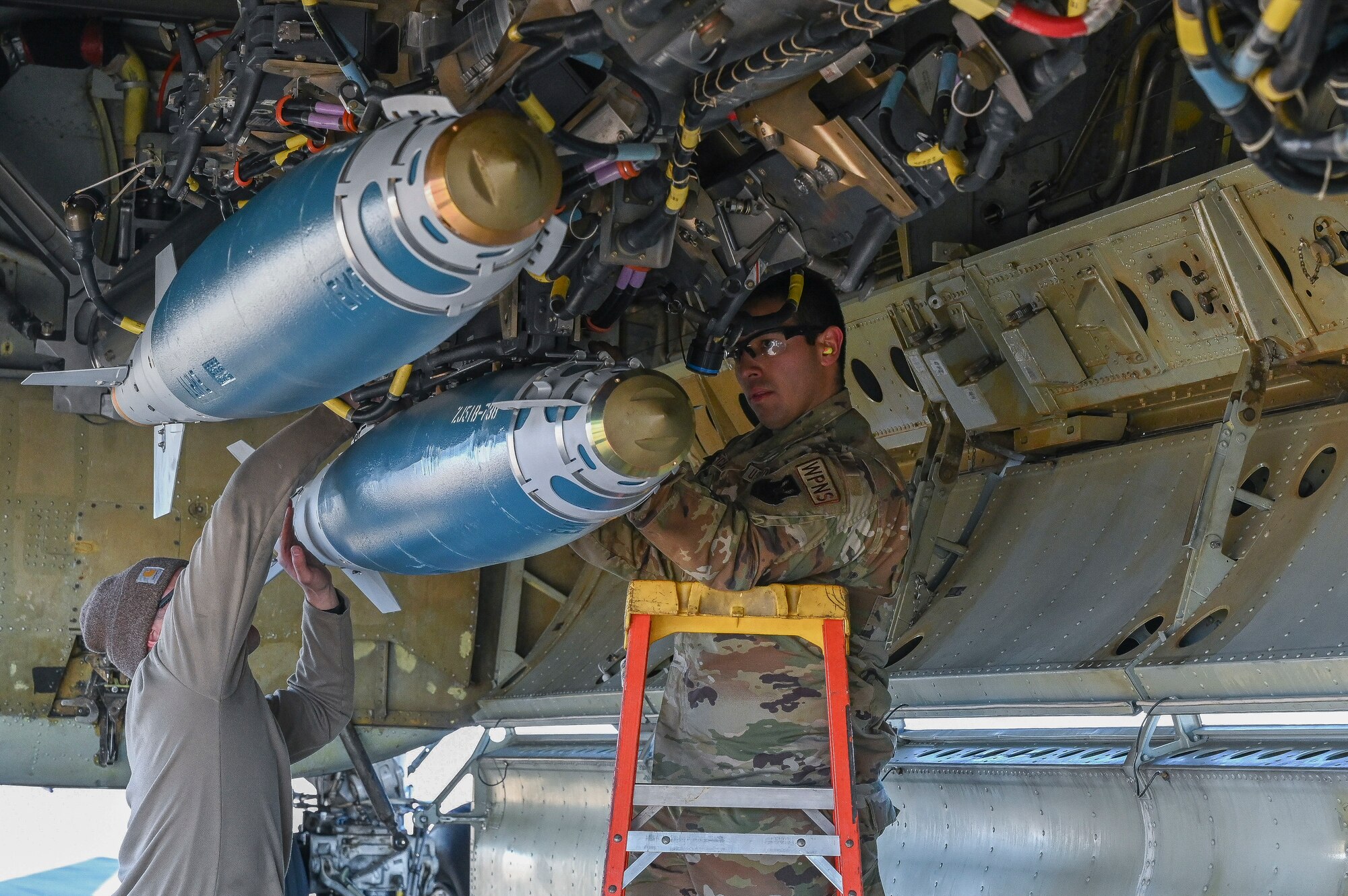 Airmen secure a munition onto a B-52 Stratofortress