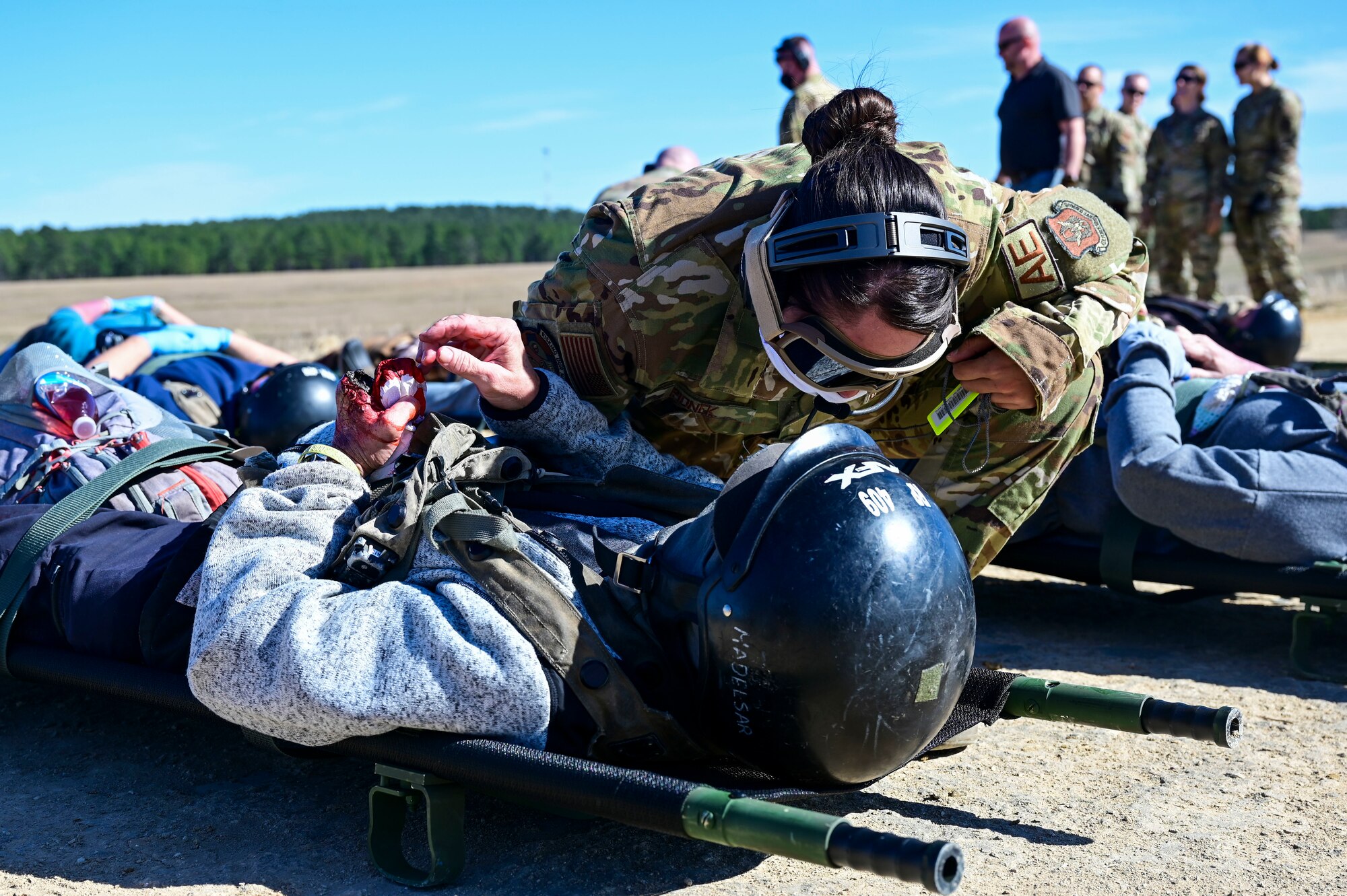 A person treats a patient with simulated injuries during an Aeromedical Evacuation exercise