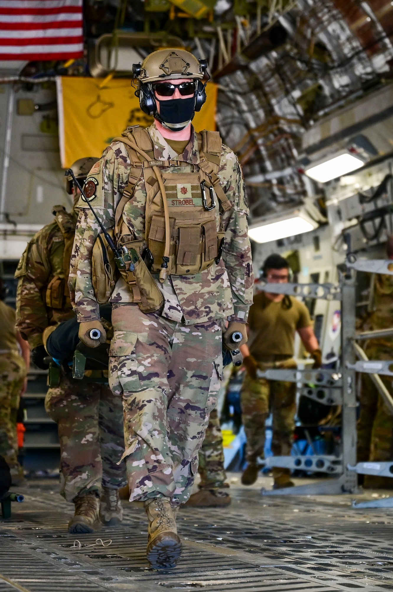 Airmen transport patients with simulated injuries off of a C-17 Globemaster III
