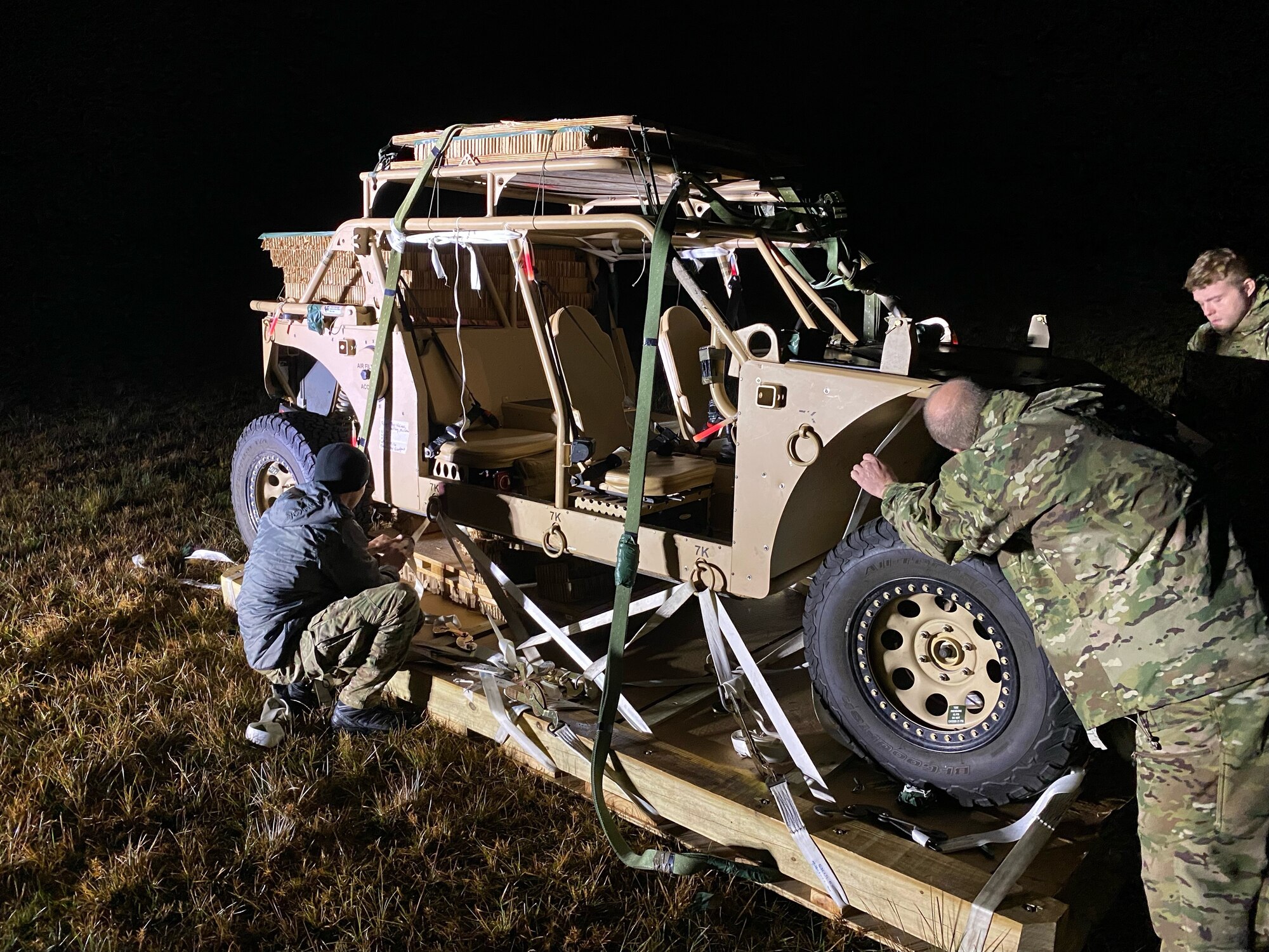 Photo of Airmen around a vehicle in a field