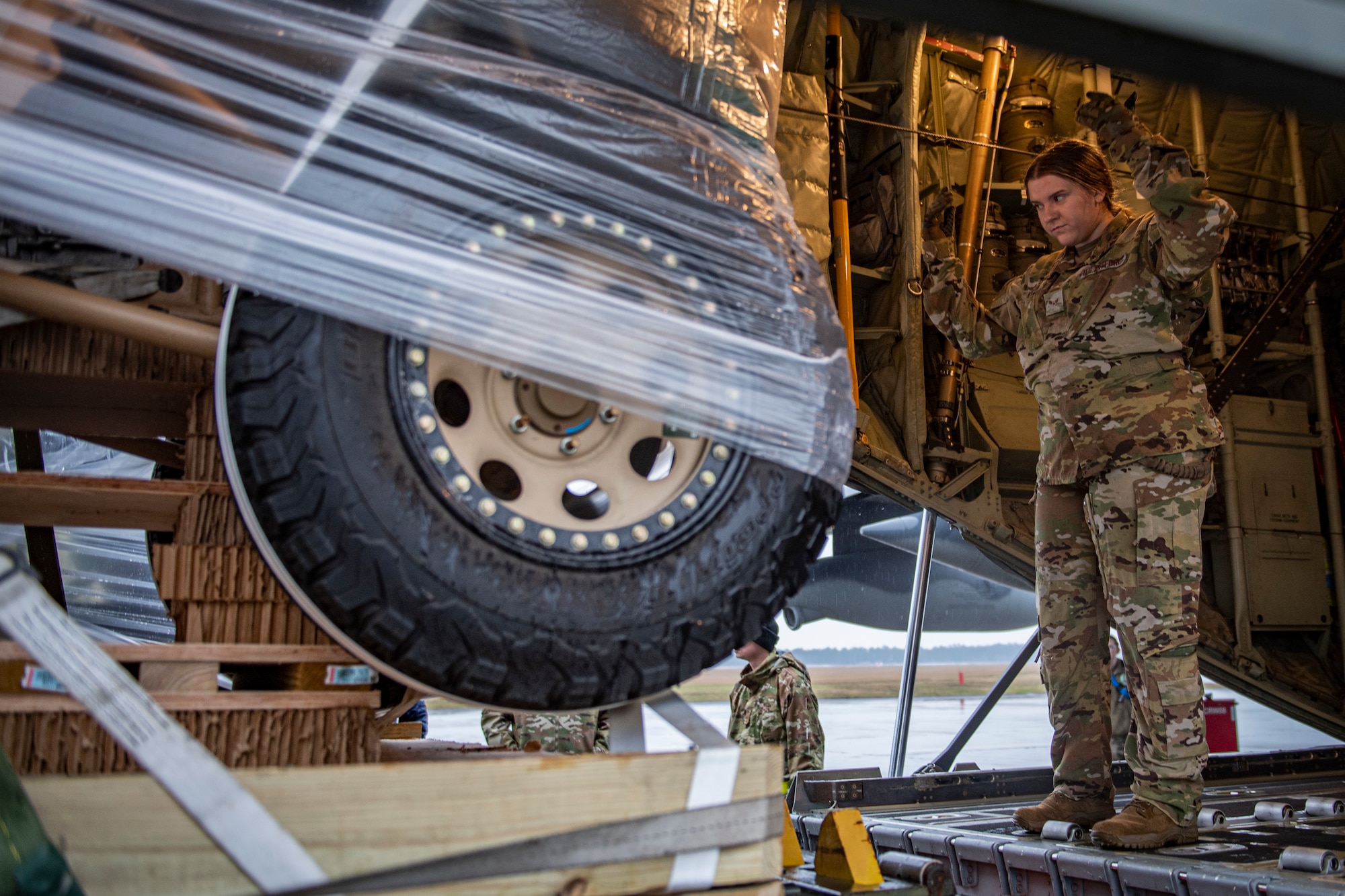 Photo of Airman guiding cargo onto an aircraft