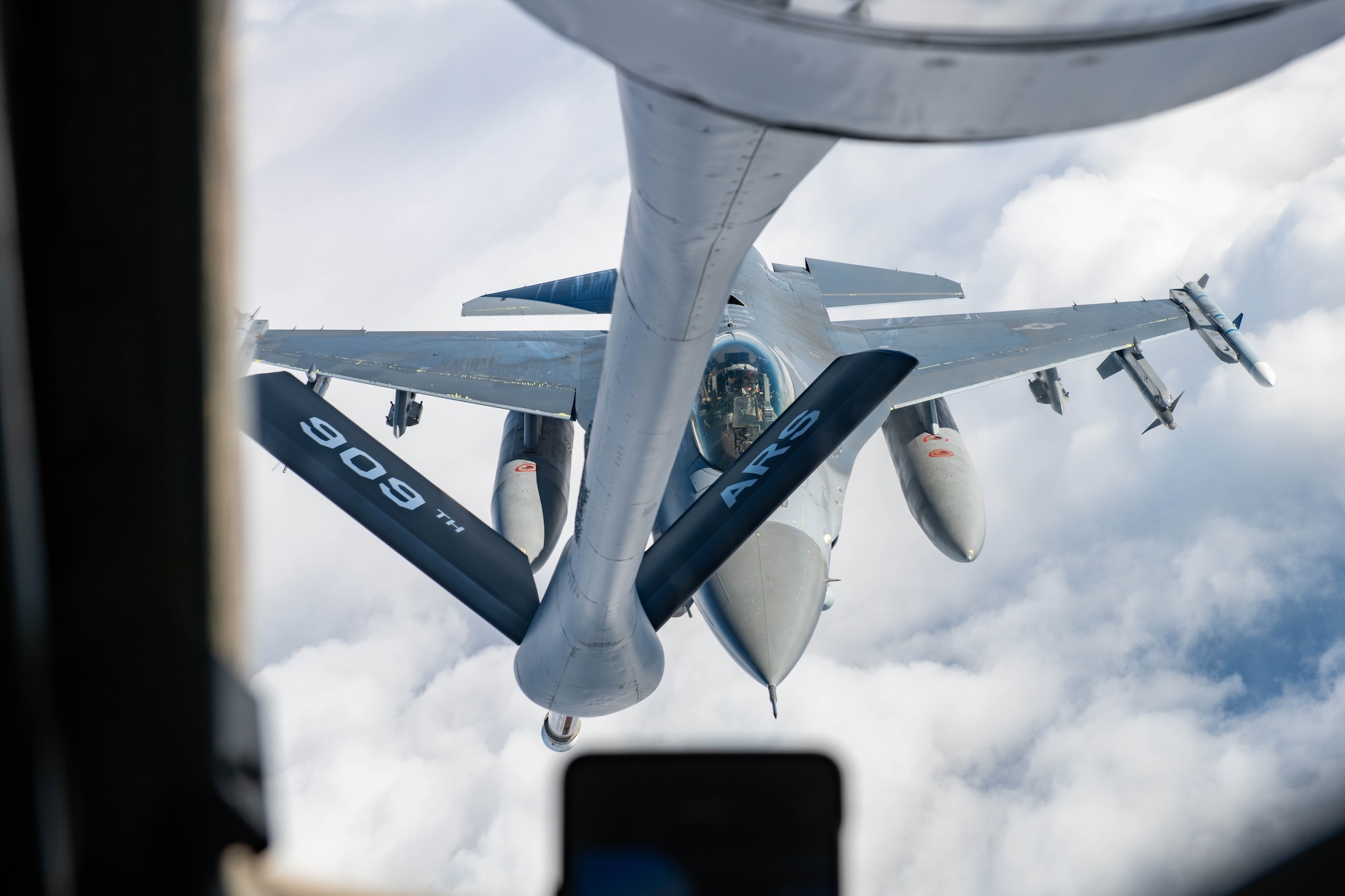 A fighter jet approaches a refueling plane