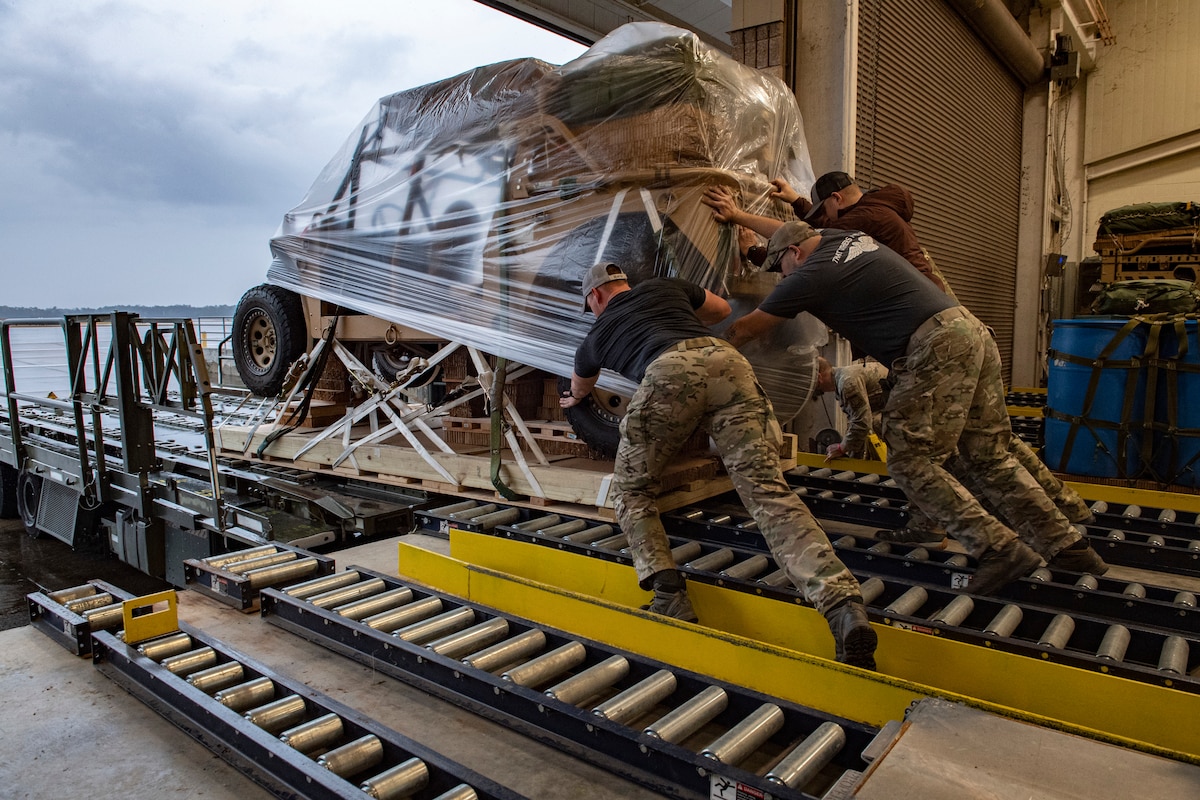 Photo of Airmen pushing cargo onto a loader