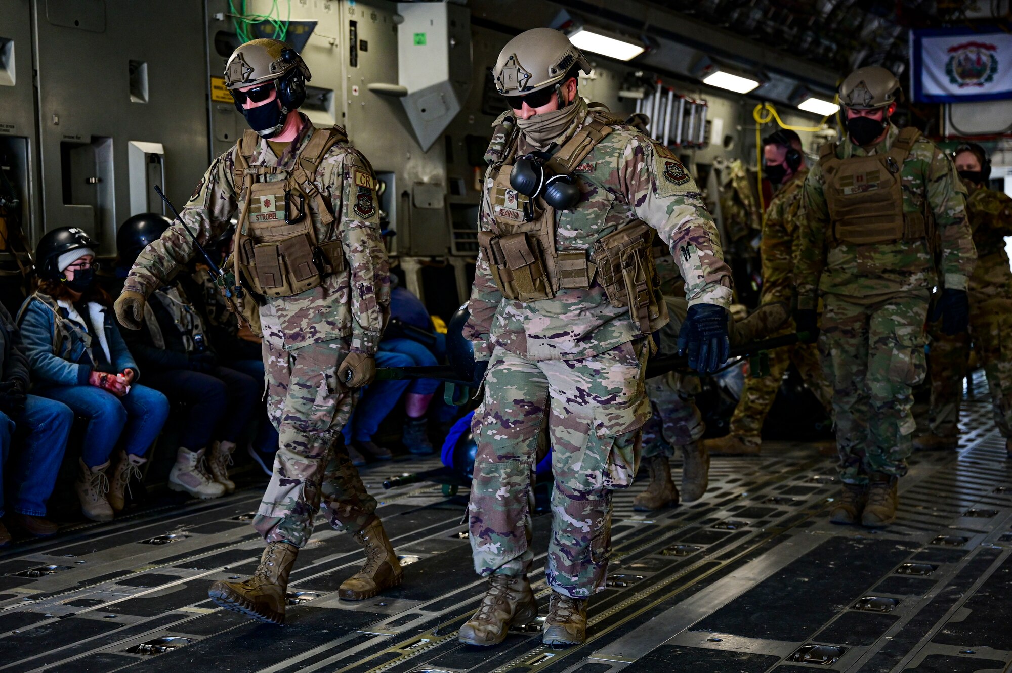 Airmen transport patients with simulated injuries off of a C-17 Globemaster III