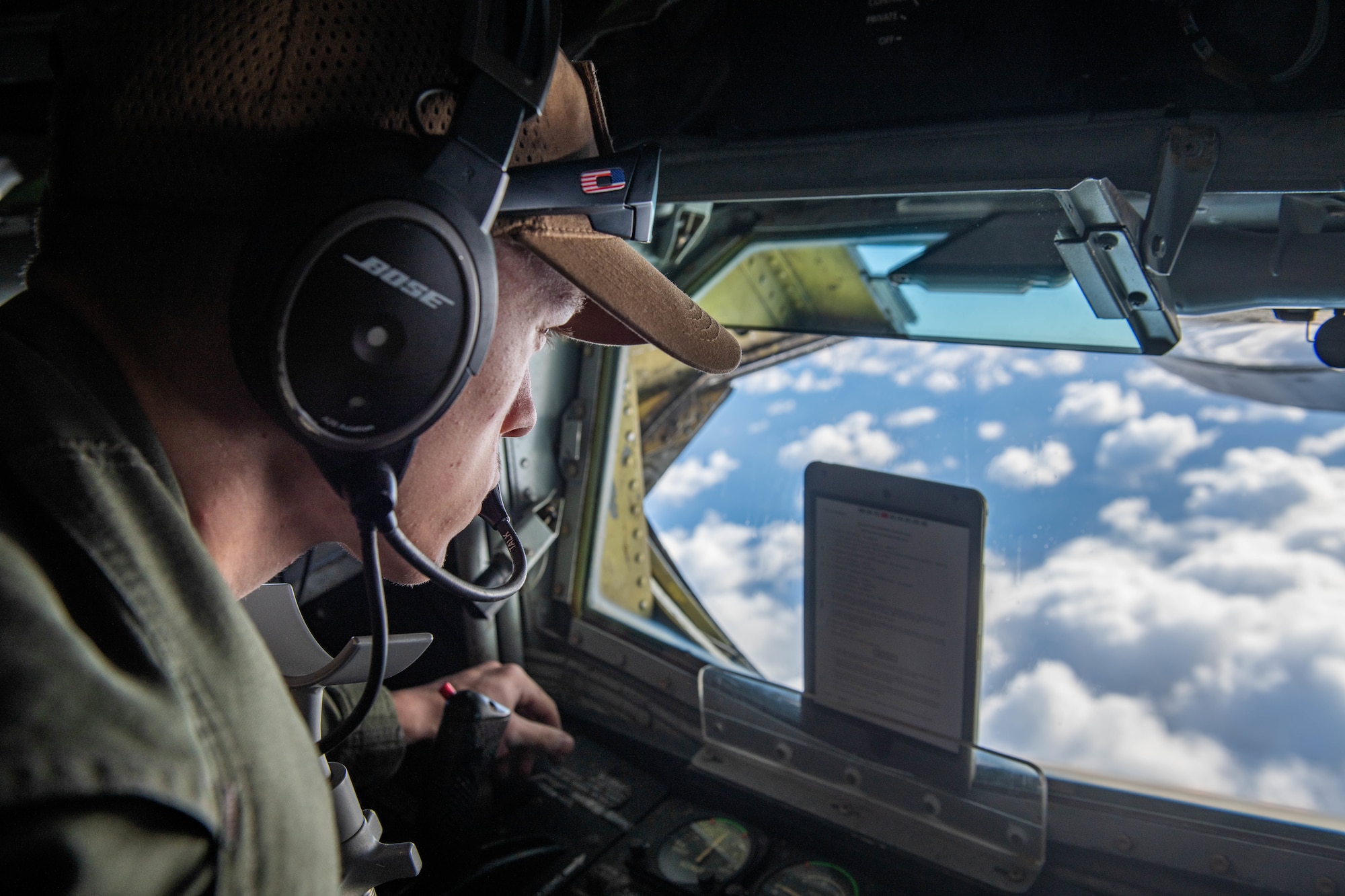 An Airman prepares to refuel a jet from the back of a plane