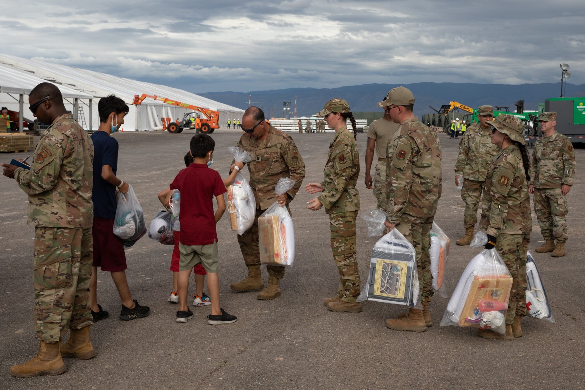 Lt. Col. Panos Bakogiannis hands out basic essentials to arriving Afghan evacuees at Holloman. (Army Photo by Spc. Nicholas Goodman)