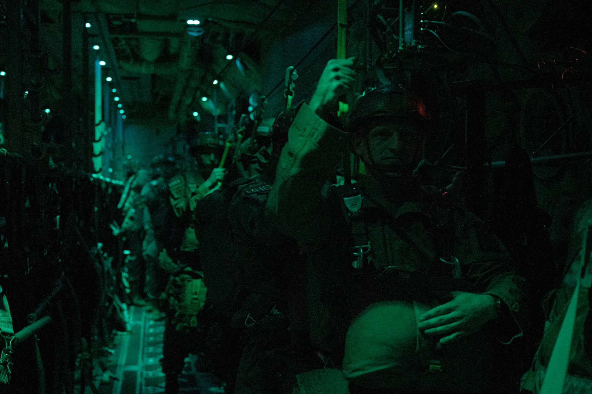 Army paratroopers with the 1st Battalion, 509th Infantry Regiment, prepare to jump out of a C-130J Super Hercules