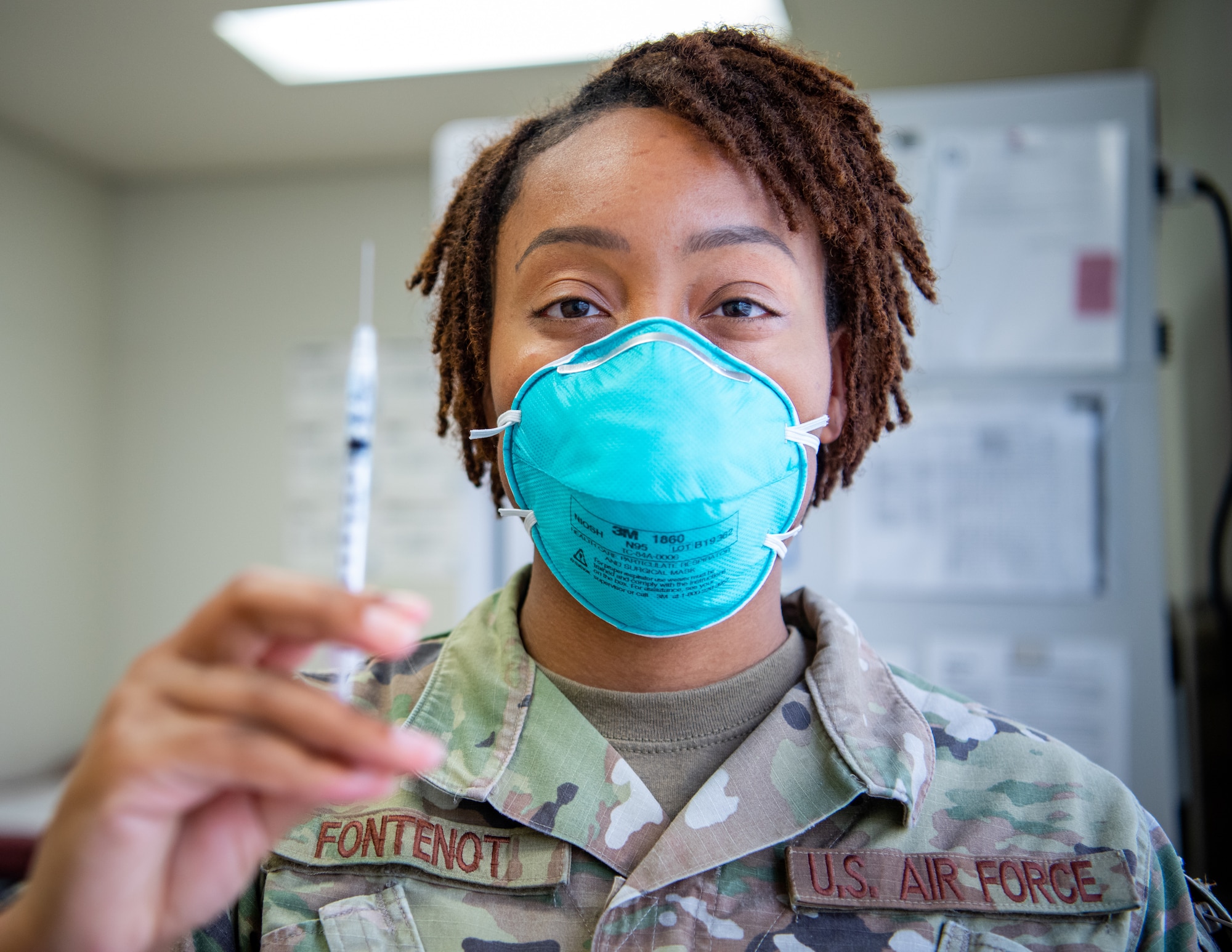 A medical technician holds up a syringe containing the COVID-19 vaccine.