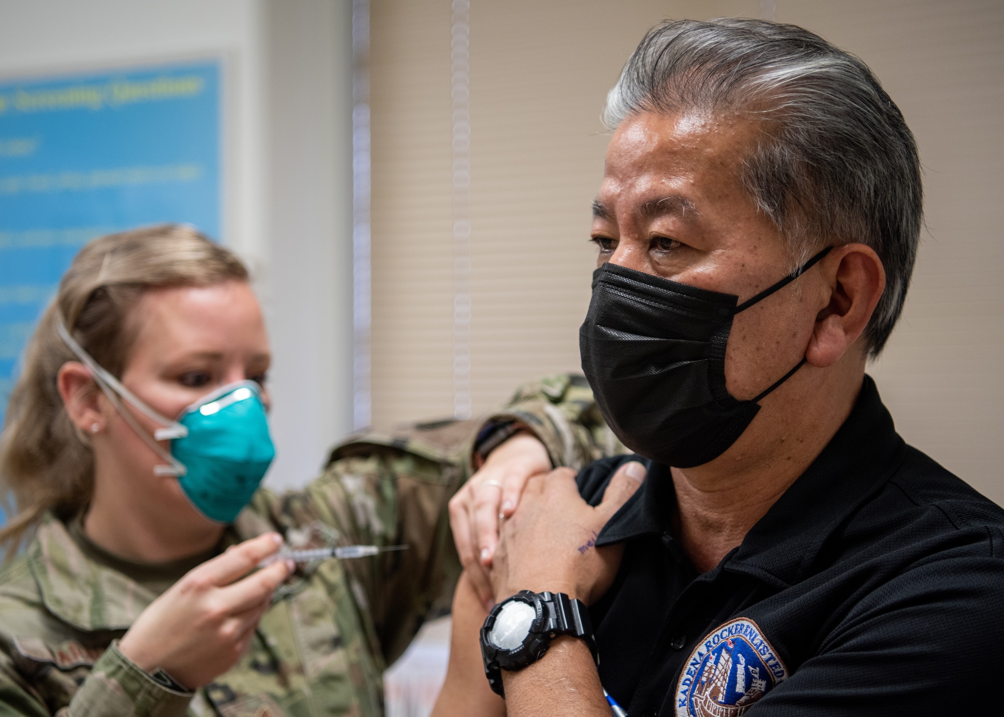 A medical technician administers a COVID-19 vaccine to a patient.