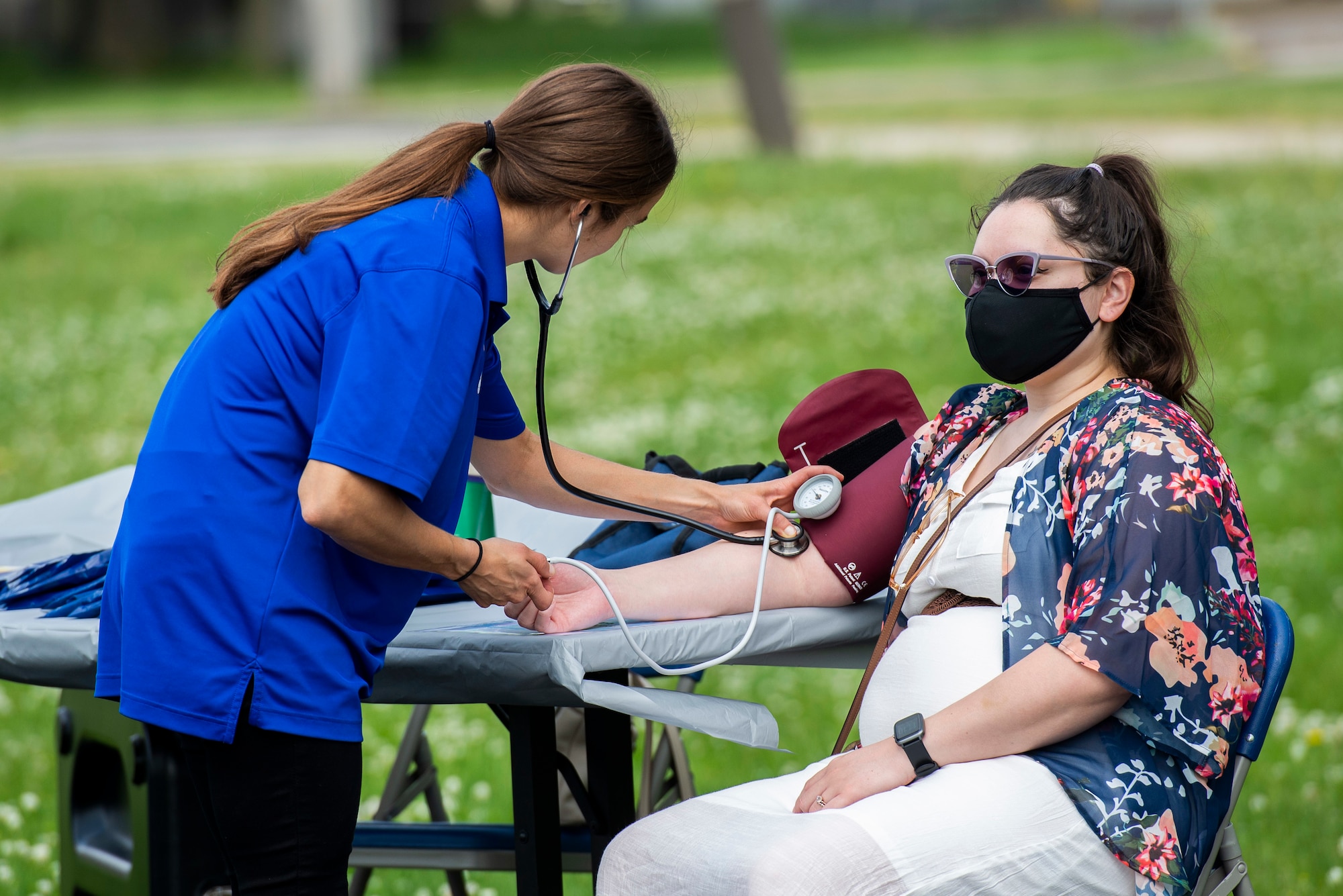 Oliva Lehman, a health promotion coordinator with Civilian Health Promotion Services, checks the blood pressure of Christina Pico-Carbajal a base dependent during the annual Wright-Patterson Air Force Base, Ohio, Fit Fest event, May 27, 2021. During the event people were able to get information about physical and mental health, as well as participate in physical competitions. (U.S. Air Force photo by Wesley Farnsworth)