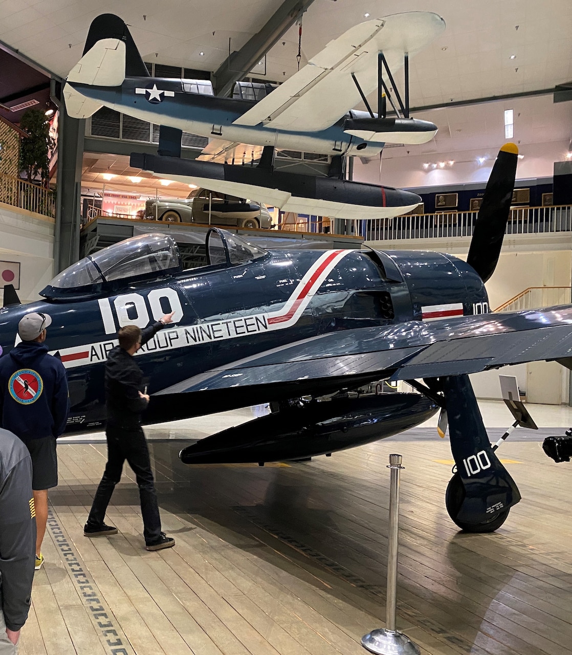 Navy dive team examining features of the existing F8F Bearcat on display at the National Naval Aviation Museum