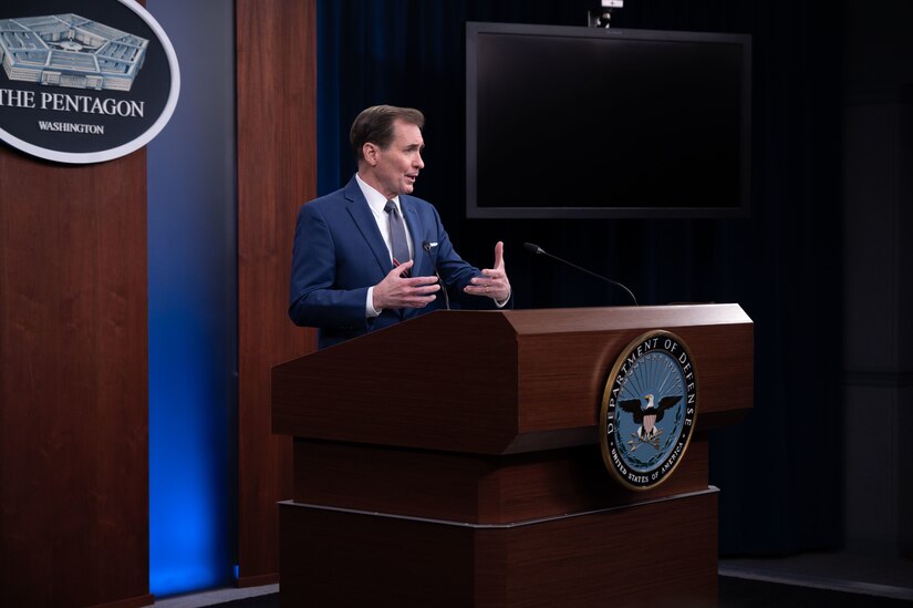 A man speaks from a lectern at a news conference. The sign behind him indicates that he is at the Pentagon.