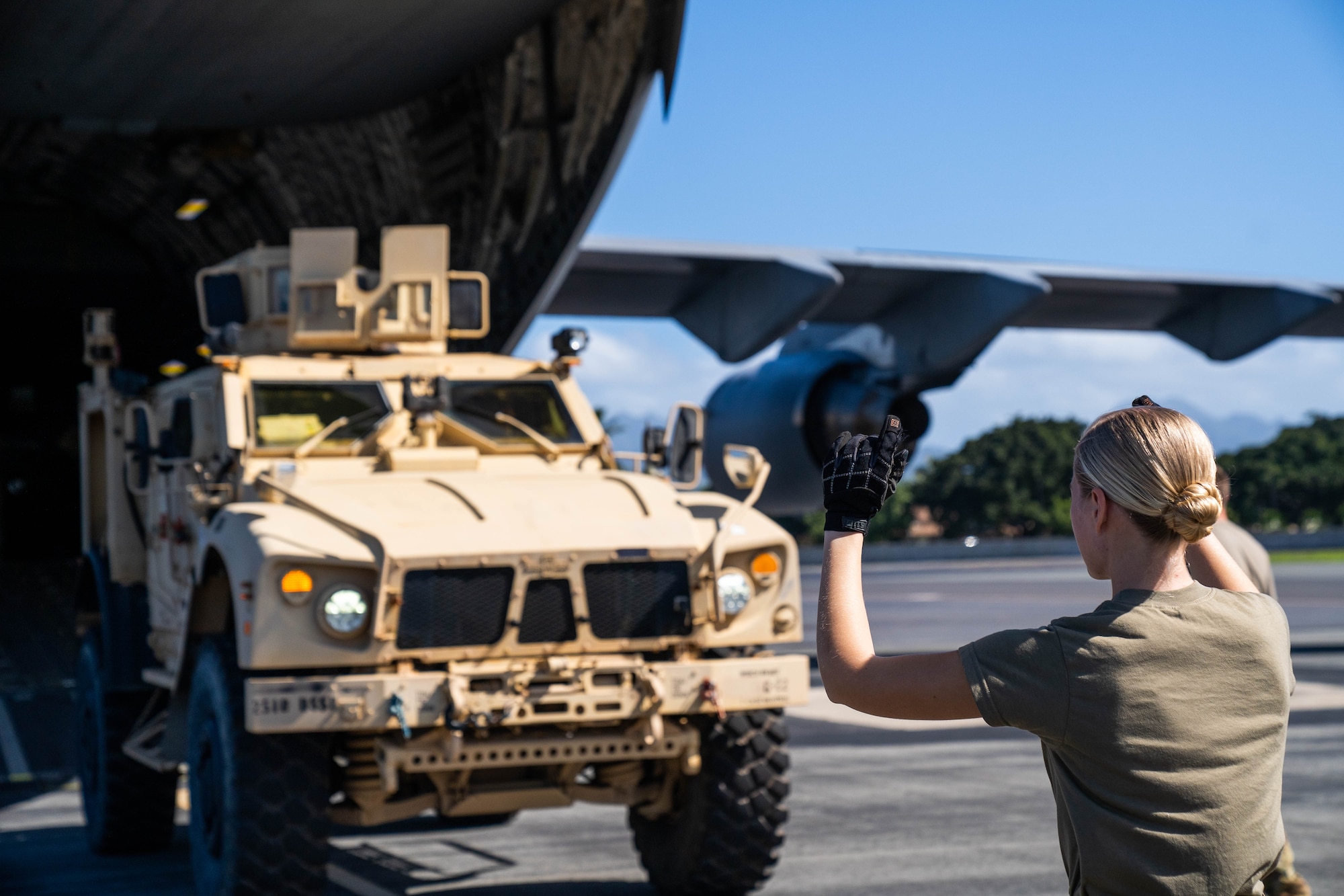Senior Airman Maya France, 535 Airlift Squadron loadmaster, directs a Joint Light Tactical Vehicle onto a C-17 Globemaster III during an exercise at Joint Base Pearl Harbor-Hickam, Hawaii, Jan. 10, 2022. Loadmasters direct and secure cargo while working hand-in-hand with joint and total force partners to ensure a free and open Indo-Pacific. (U.S. Air Force photo by Airman 1st Class Makensie Cooper)