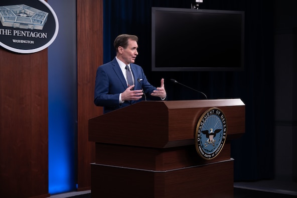 A reporter raises her hand to be recognized at a Pentagon news conference.