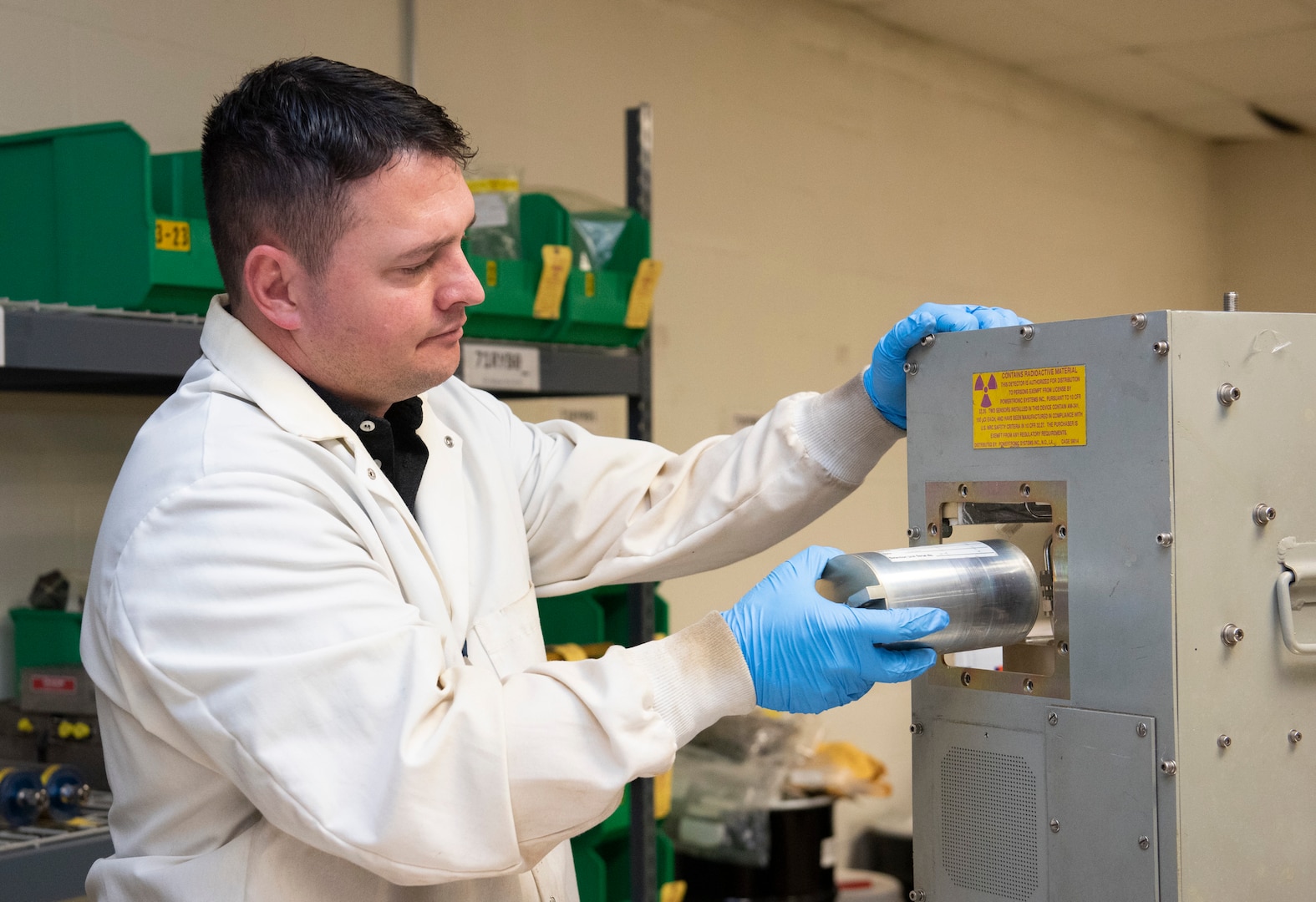 Seth Walton removes a part containing radioactive material that will be properly recycled or disposed of by the Air Force Radioactive Recycling and Disposal team, Dec. 1, 2021 at Wright-Patterson Air Force Base, Ohio. Air Force Radioactive Recycling and Disposal (AFRRAD) is the primary focal point for radioactive recycling and waste management within the Air Force. (U.S. Air Force photo by Jaima Fogg)