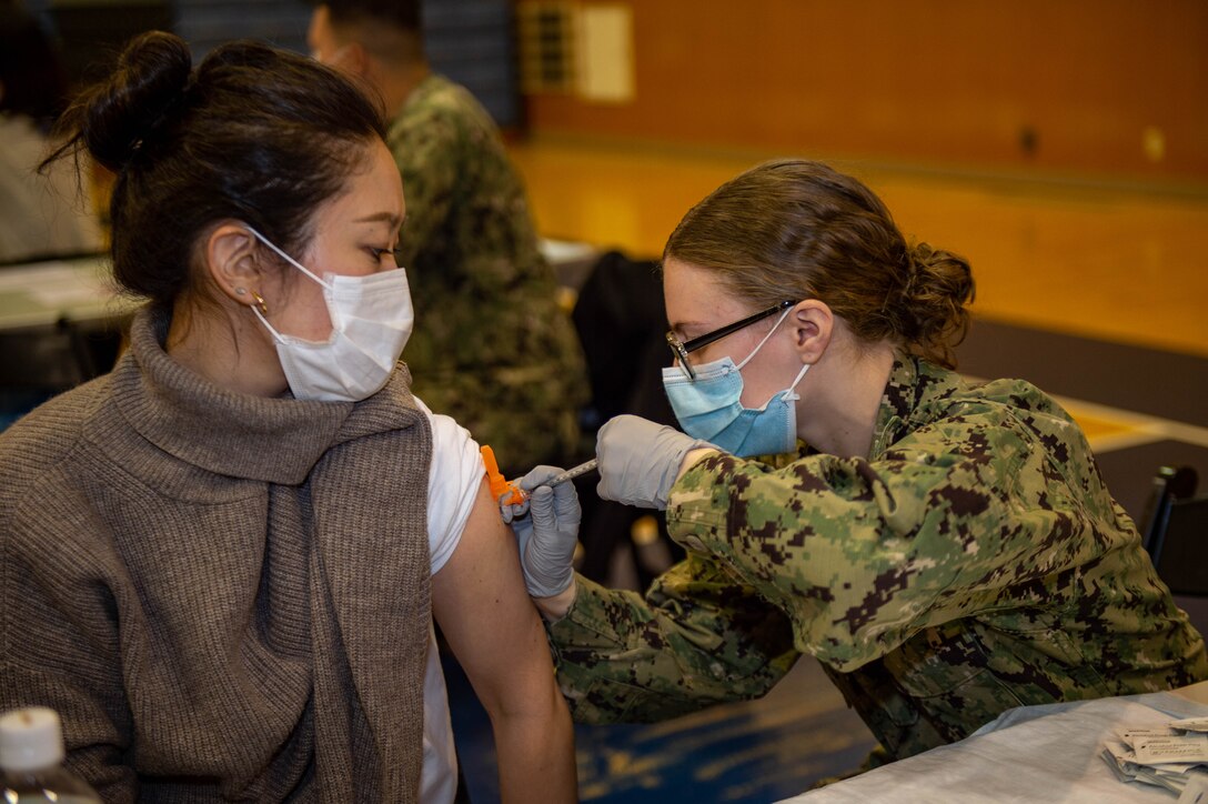 220128-N-SI601-1059 YOKOSUKA, Japan (Jan. 28, 2022) Hospital Corpsman 3rd Class Courtney Minchew, from Ocala, Florida, assigned to the U.S. Navy’s forward-deployed aircraft carrier USS Ronald Reagan (CVN 76), administers a COVID-19 vaccination booster to a Japanese base employee on Commander, Fleet Activities Yokosuka. Ronald Reagan, the flagship of Carrier Strike Group 5, provides a combat-ready force that protects and defends the United States, and supports alliances, partnerships and collective maritime interests in the Indo-Pacific region. (U.S. Navy photo by Mass Communication Specialist 3rd Class Daniel G. Providakes)