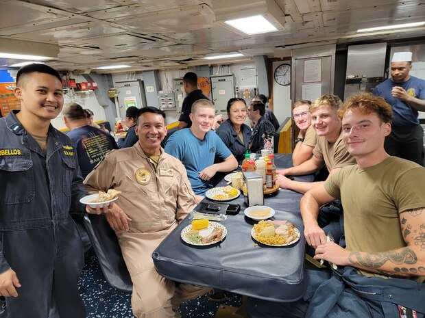 211125-N-N0146-1001 MANAMA, Bahrain (Nov. 25, 2021)
Capt. Ernan Obellos, center, and Lt. j. g. Elvin-John Obellos, left, pose for a photo aboard Mine Countermeasures Ship USS Gladiator (MCM 11) during the thanksgiving meal aboard the ship, Nov. 25. Obellos served on active duty for 33 years, both of his sons followed his example by becoming officers in the U.S. Navy, and both deployed to the same geographical location as their father. (Photo courtesy of Ernan Obellos)