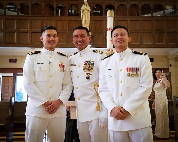 190928-N-N0146-1001 (Sept. 28. 2019)
Capt. Ernan Obellos, center, Lt. j. g. Elvin-John Obellos, left, and Lt. Kristopher-Louis Obellos, right, pose for a photo Sept. 28. Obellos served on active duty for 33 years, both of his sons followed his example by becoming officers in the U.S. Navy, and both deployed to the same geographical location as their father. (Photo courtesy of Ernan Obellos)