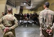 Sgt. Bryan Karp and Sgt. Tavin Bromell, stand at parade rest as they await to address a room of well-wishers during a promotion ceremony to their current rank Jan. 1, 2022. Karp and Bromell are military police Soldiers currently assigned to the Fort Stewart, Georgia-based, 293rd Military Police Company, in Qatar with the Afghan Evacuation Mission Support Element.