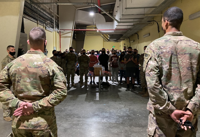 Sgt. Bryan Karp and Sgt. Tavin Bromell, stand at parade rest as they await to address a room of well-wishers during a promotion ceremony to their current rank Jan. 1, 2022. Karp and Bromell are military police Soldiers currently assigned to the Fort Stewart, Georgia-based, 293rd Military Police Company, in Qatar with the Afghan Evacuation Mission Support Element.