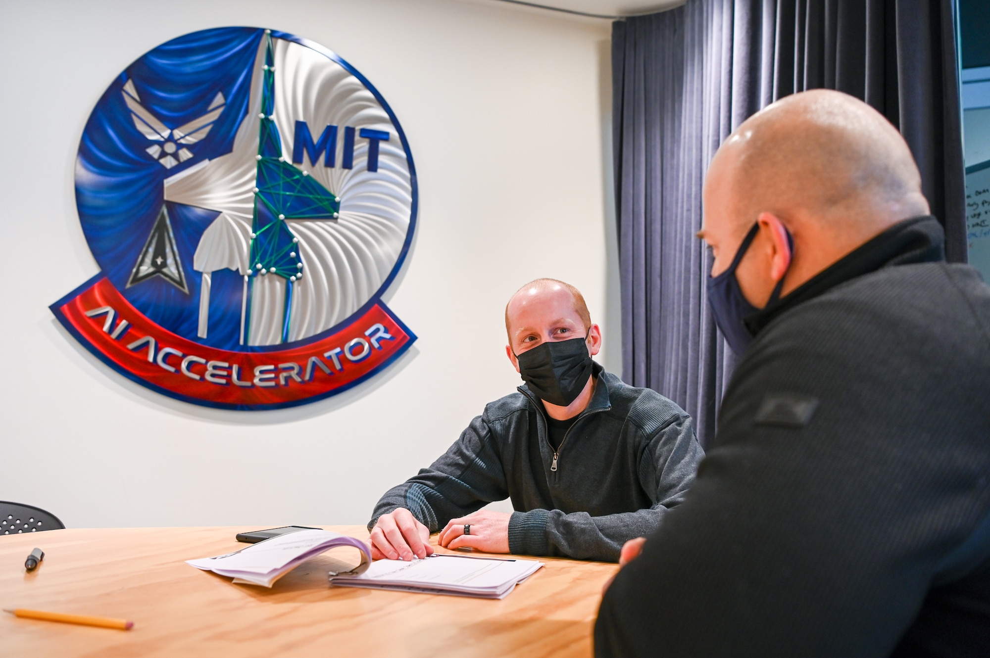 Capt. Matt Ruden speaks with Capt. Samuel Howard at the Department of the Air Force-Massachusetts Institute of Technology Artificial Intelligence Accelerator in Cambridge, Mass., Jan. 27.