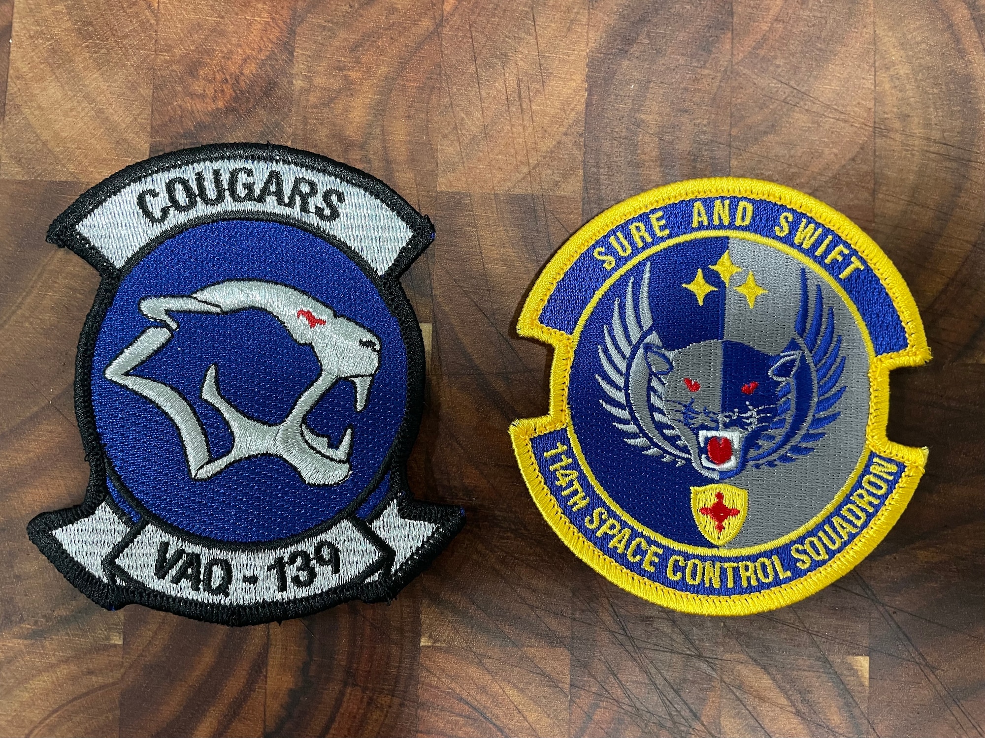 Pictured are the official patches of the U.S. Navy’s Electronic Attack Squadron 139 (VAQ-139), and the U.S. Air Force's 114th Space Control Squadron, who are known as the "Cougars" and "Thundercats," respectively. The squadrons collaborated in December 2021 during a two-day mission coined Operation SPACECAT. The purpose of the mission was to share best practices among tactical Electromagnetic Warfare experts about the capabilities of systems and learn about space missions in and around Cape Canaveral Space Station, FL.