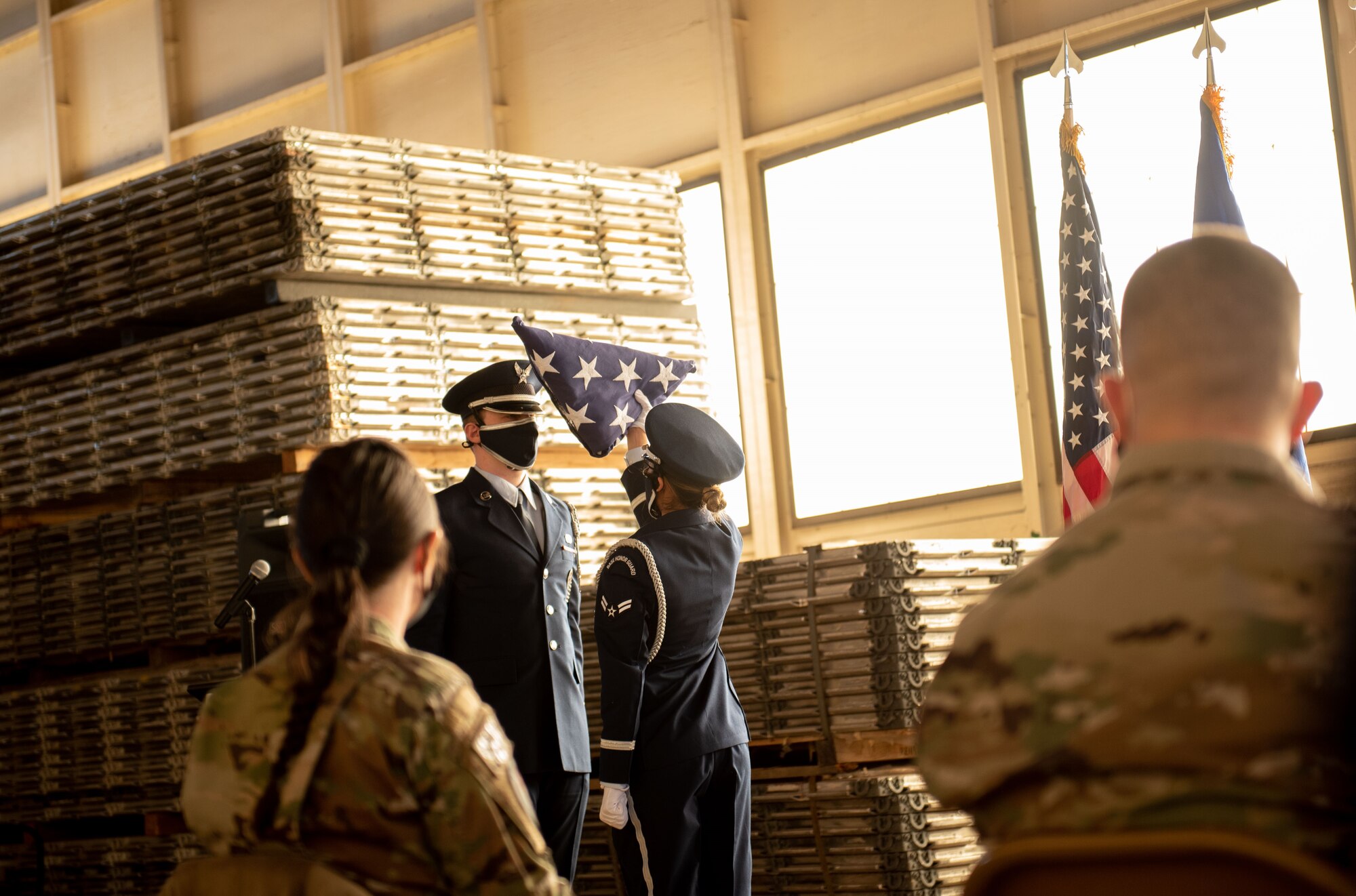 honorguardsman holds flag above her head during a flag folding ceremony