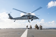 Explosive Ordnance Disposal Mobile Unit (EODMU) 2 assigned to Carrier Strike Group 8 and an MH-60S Sea Hawk helicopter assigned to the "Dragon Slayers" of Helicopter Sea Combat Squadron (HSC) 11, conducts a fast roping evolution with the Norwegian Royal Navy Fridtjof Nansen-class frigate HNoMS Fridtjof Nansen (F310) during Neptune Strike 2022,