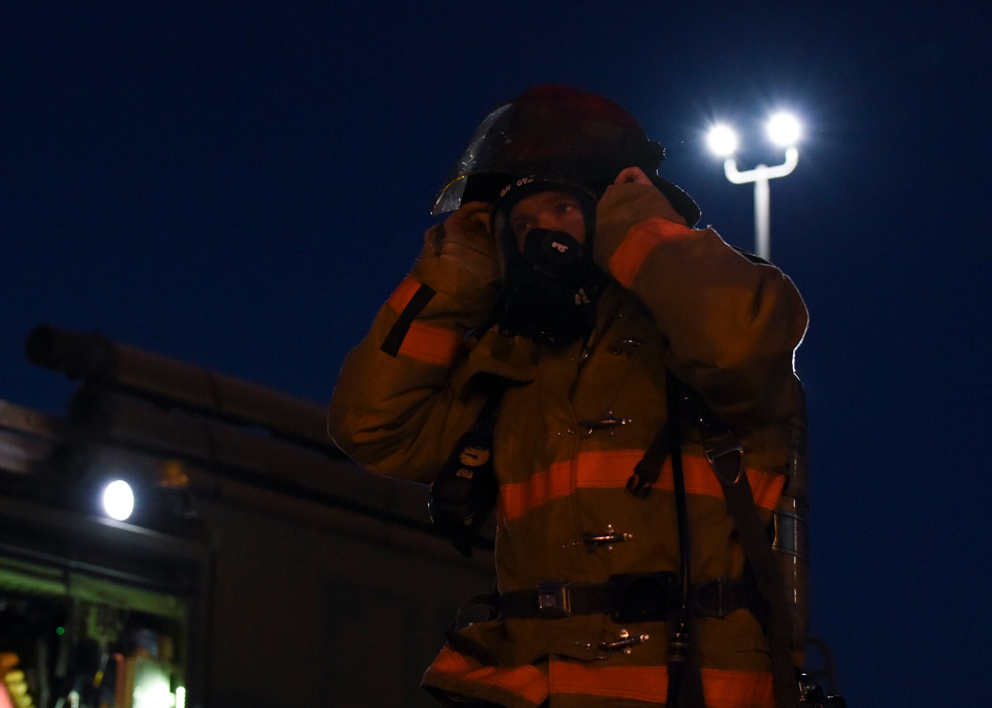U.S. Air Force Tech. Sgt. Kenneth Colton, 312th Training Squadron fire officer training section chief, dons his protective fire protection gear during a training exercise at the Louis F. Garland Department of Defense Fire Academy