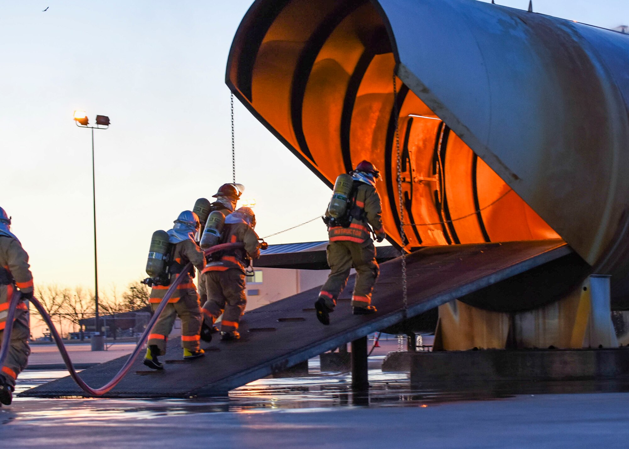 U.S. Air Force Tech. Sgt. Kenneth Colton, 312th Training Squadron fire officer training section chief, leads Airmen into a fire training simulator at the Louis F. Garland Department of Defense Fire Academy