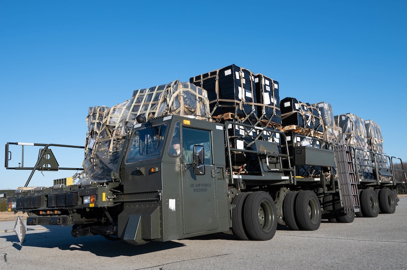 Pallets with cargo are atop a military truck.