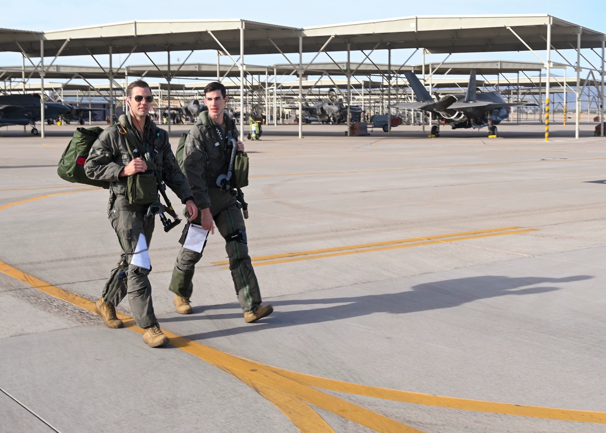 U.S. Air Force Capt. Sean “Echo” Gossner, 63rd Fighter Squadron F-35A Lightning II instructor pilot (left), and his brother 1st Lt. Nicholas “Trek” Gossner, 308th FS F-35A student pilot (right), step out to the flight line Jan. 12, 2022, at Luke Air Force Base, Ariz.