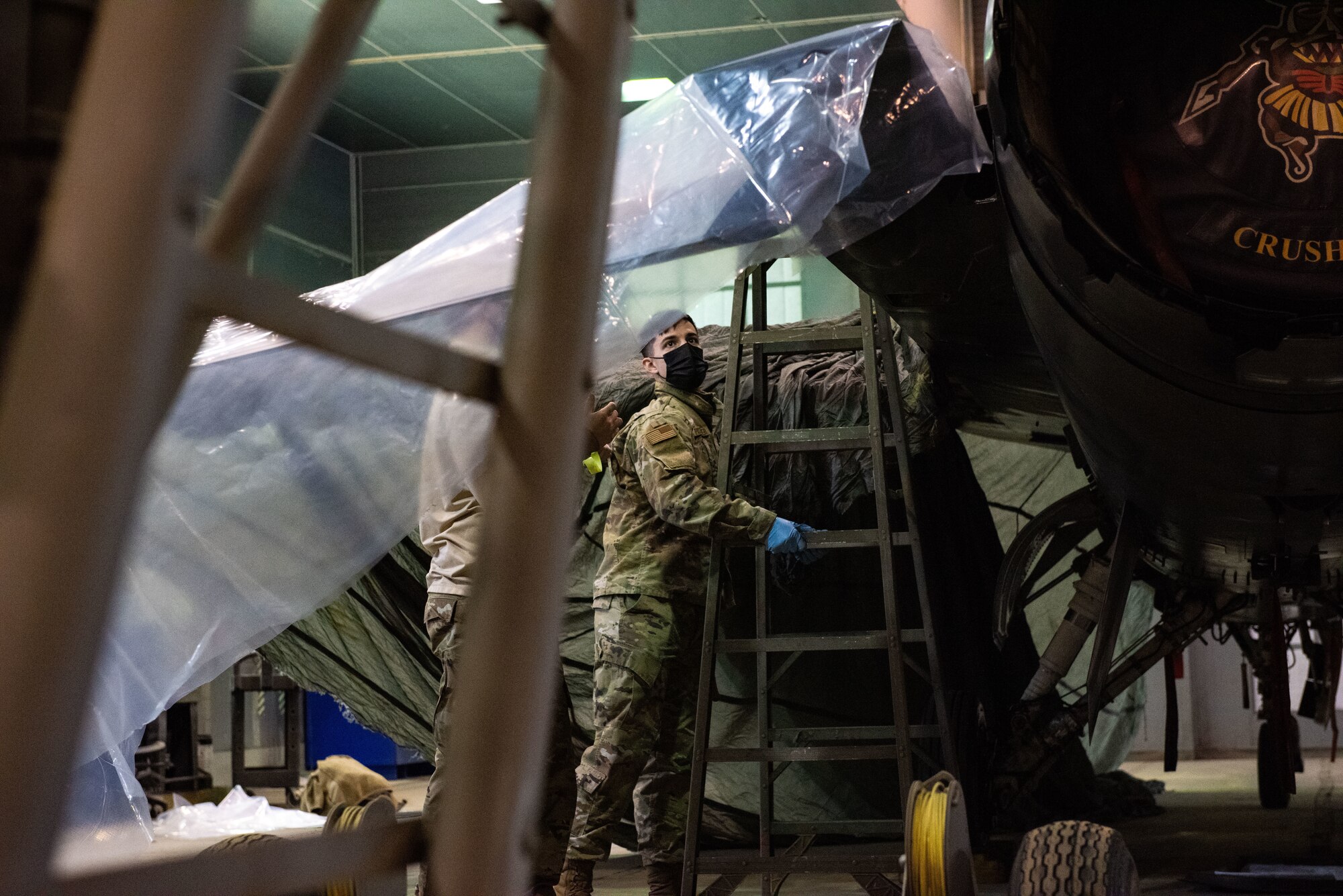 Staff Sgt. Samuel Harris, 8th Maintenance Squadron aircraft structural maintenance craftsman, applies tape and plastic to an F-16 Fighting Falcon in preparation to paint a heritage tail flash
