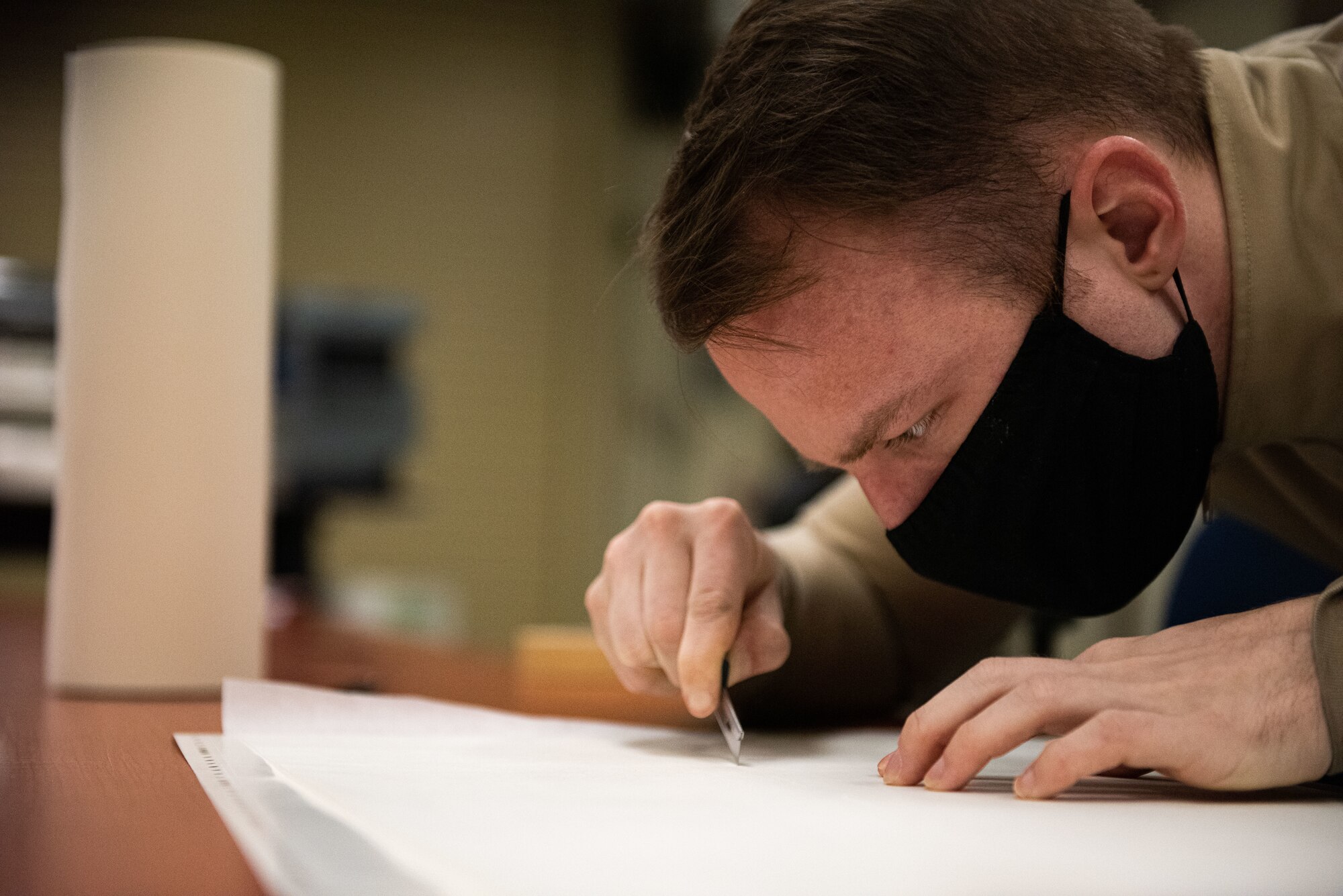 Staff Sgt. Alex Dixon, 8th Maintenance Squadron aircraft structural maintenance journeyman, cuts out stencils to be used for the 8th Operations Group tail flash