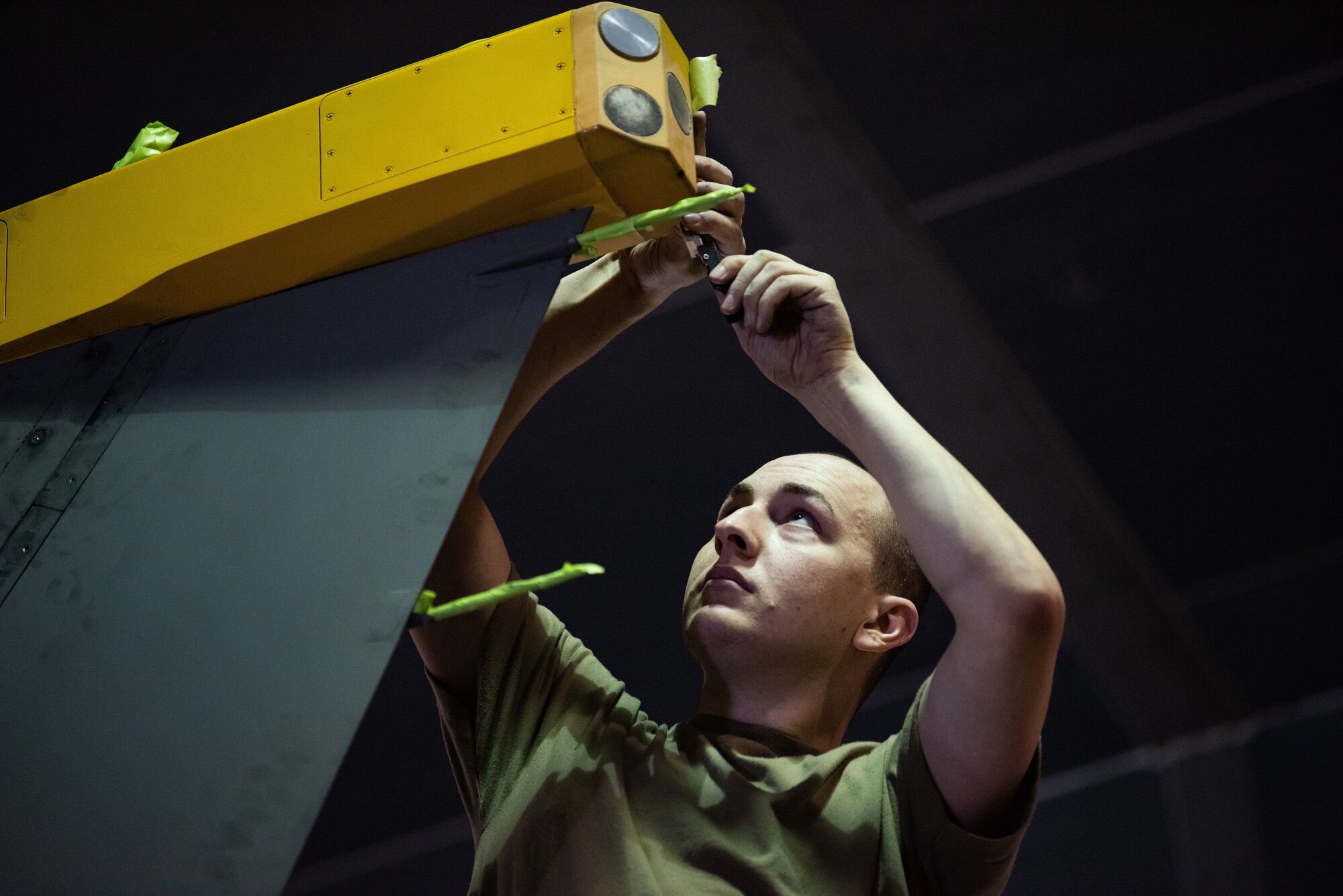 Senior Airman Scott Bradshaw, 8th Maintenance Squadron aircraft structural maintenance journeyman applies masking tape to an F-16 Fighting Falcon in preparation for the painting of a heritage tail flash