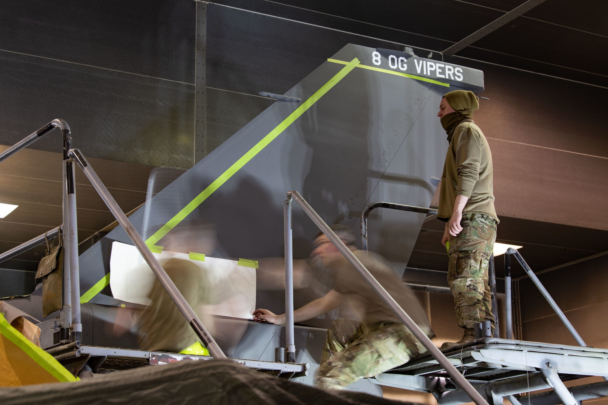 Airmen assigned to the 8th Maintenance Squadron Aircraft Structural Maintenance Corrosion Control shop work together to apply stencils for the tail flash of the 8th Operations Group’s F-16 Fighting Falcon