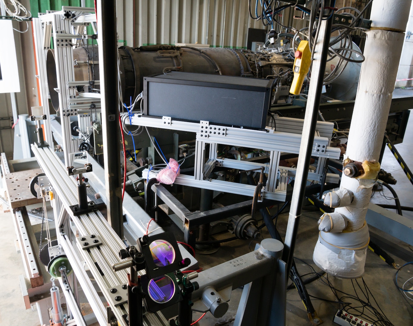 In order to non-invasively measure the unsteady, 3D velocity field of a jet plume from a stationary aircraft engine, Nov. 18, 2021, a laser beam is redirected and spread into a wider plane as it crosses behind the engine at the Propulsion Research Facility operated by Arnold Engineering Development Complex at UTSI.