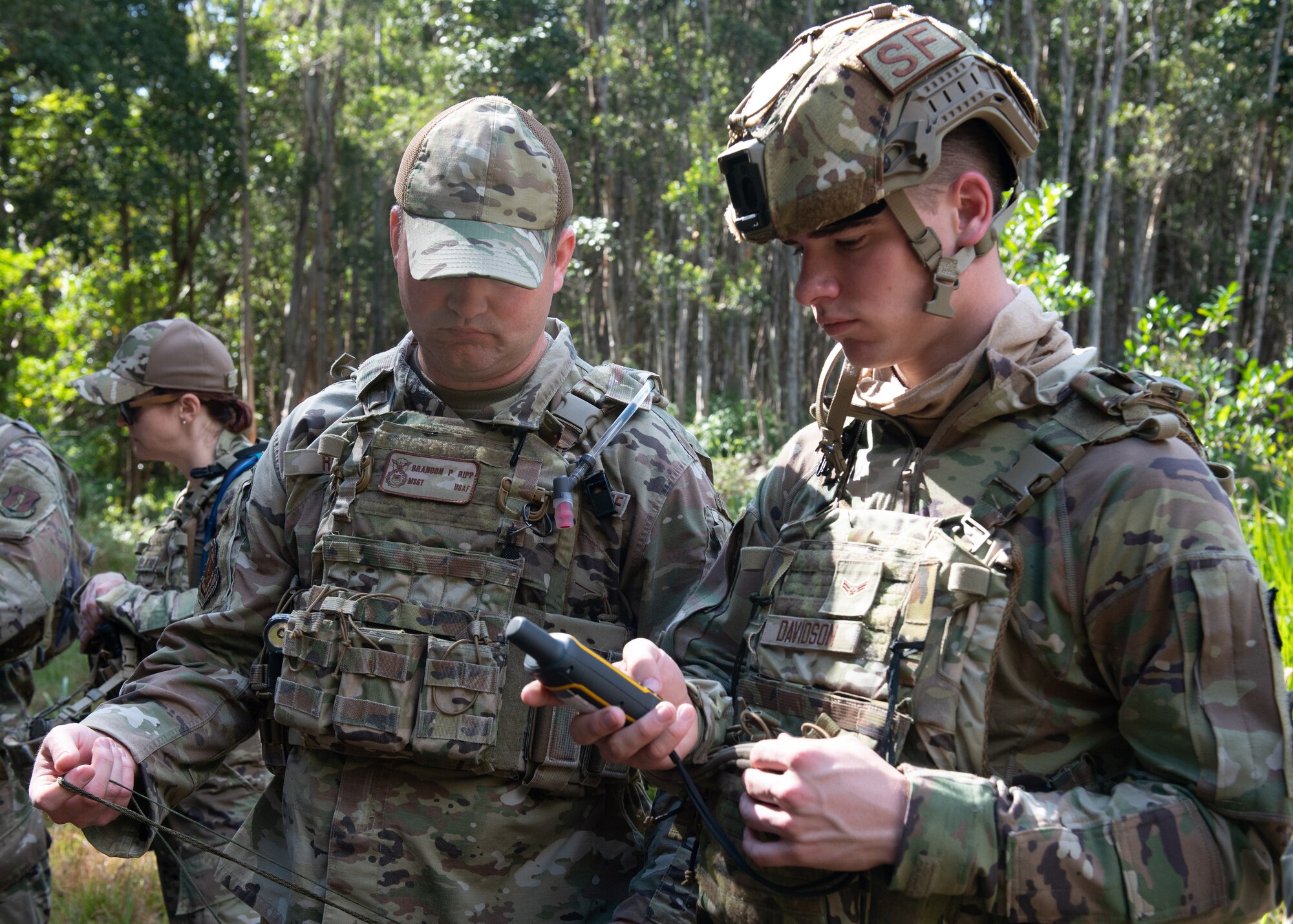 U.S. Air Force Master Sgt. Brandon Ripp, left, and Airman 1st Class Eli Davidson, security forces defenders assigned to the 115th Fighter Wing Security Forces Squadron in Madison, Wisconsin, engage in navigation training during a jungle and ocean survival course near Wahiawa, Hawaii.