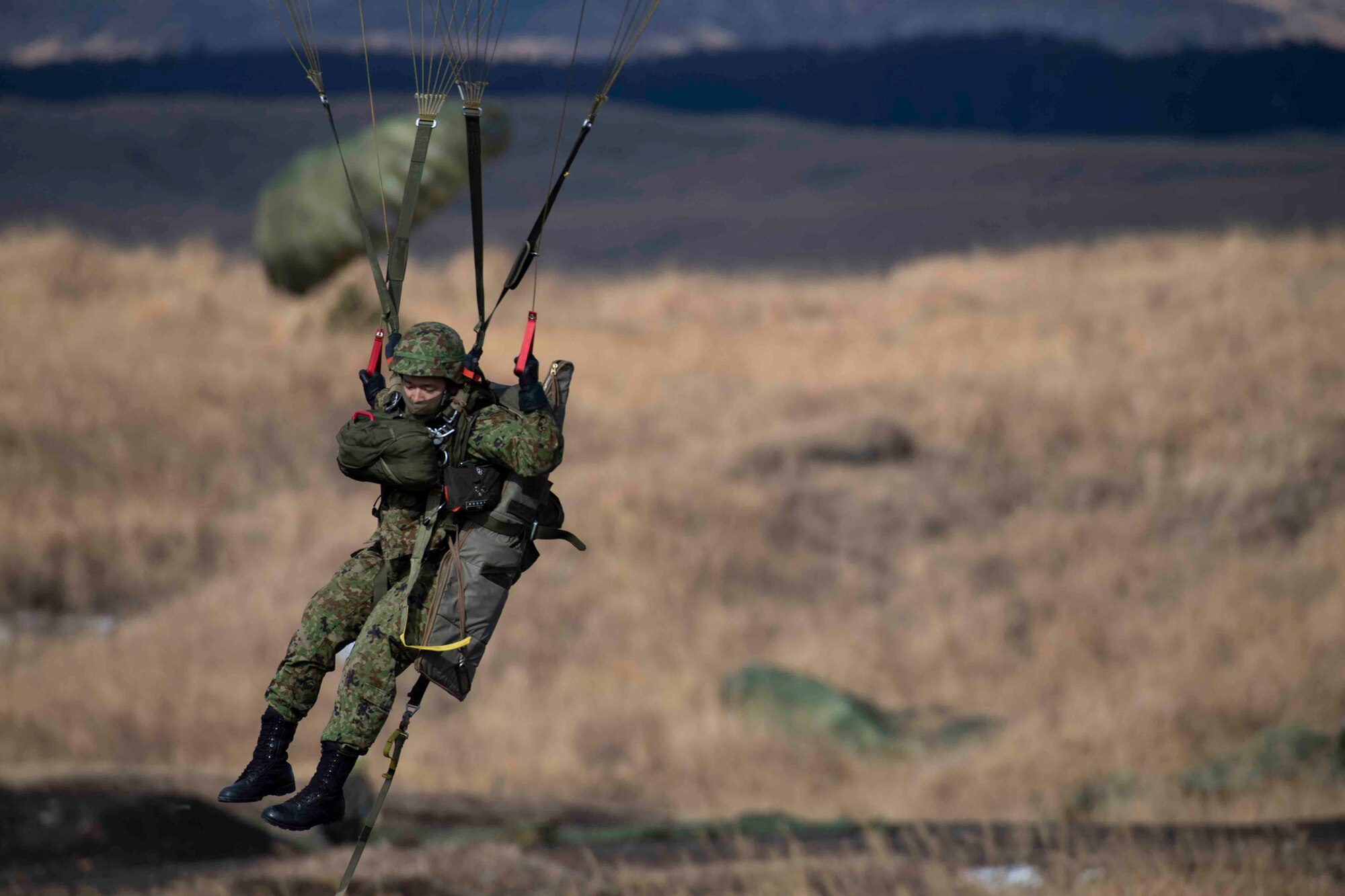 A Japan Ground Self-Defense Force paratrooper assigned to the 1st Airborne Brigade lands on the drop zone at Combined Arms Training Center Camp Fuji, Japan, during Airborne 22, Jan. 25, 2022.