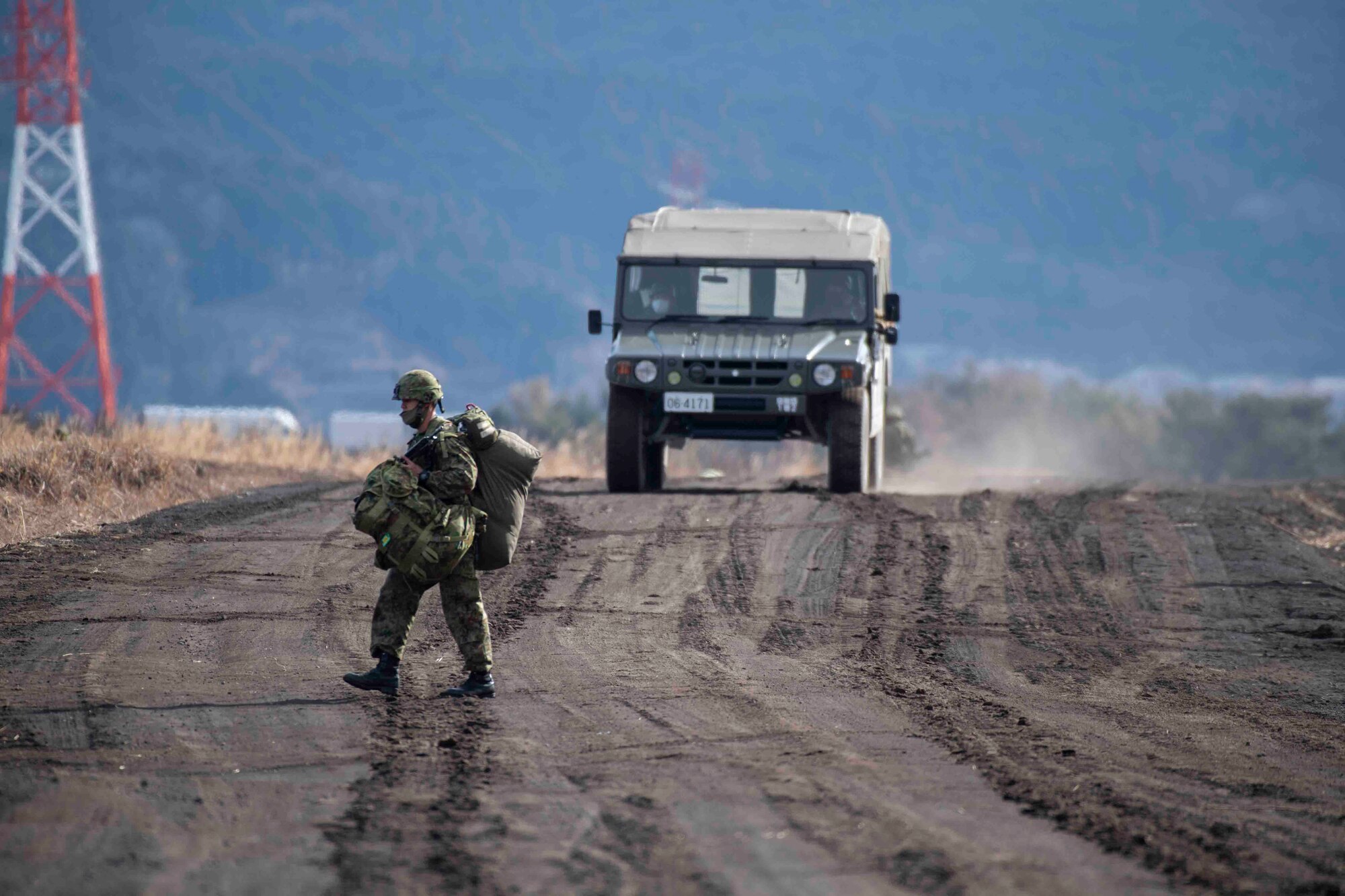 A Japan Ground Self-Defense Force paratrooper assigned to the 1st Airborne Brigade proceeds to a meeting point after completing an airborne jump from a U.S. Air Force C-130J Super Hercules assigned to the 36th Airlift Squadron at Combined Arms Training Center Camp Fuji, Japan, during Airborne 22, Jan. 25, 2022.